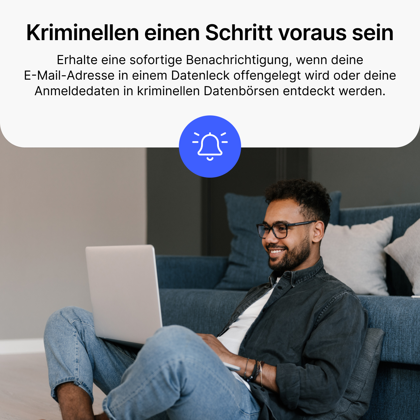 Homme assis par terre avec un ordinateur portable, icône de notification.