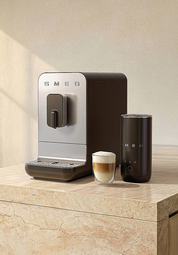 Smeg Kaffeemaschine mit Milchaufschäumer und geschichtetem Latte Macchiato im Glas.