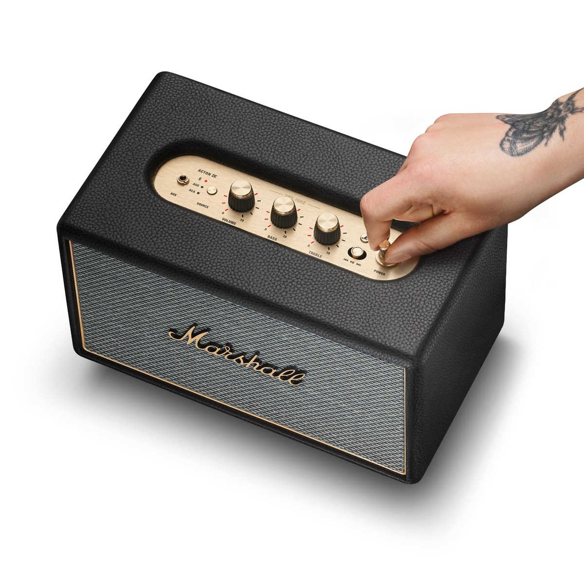 Ein schwarzer Marshall-Lautsprecher mit goldenen Reglern. Eine Hand dreht am Power-Regler.