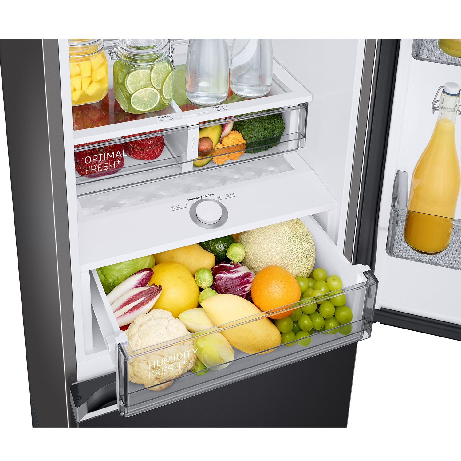 Refrigerador abierto con frutas y verduras variadas en cajones. Incluye mango, lima, naranjas, uvas, coliflor.