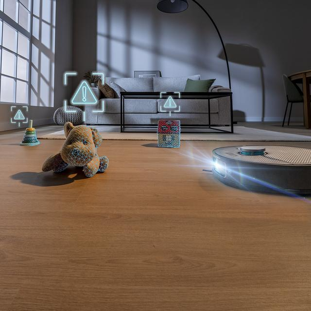 Robot süpürge, oyuncakları ve mobilyaları algılayarak bir oturma odasında geziniyor.