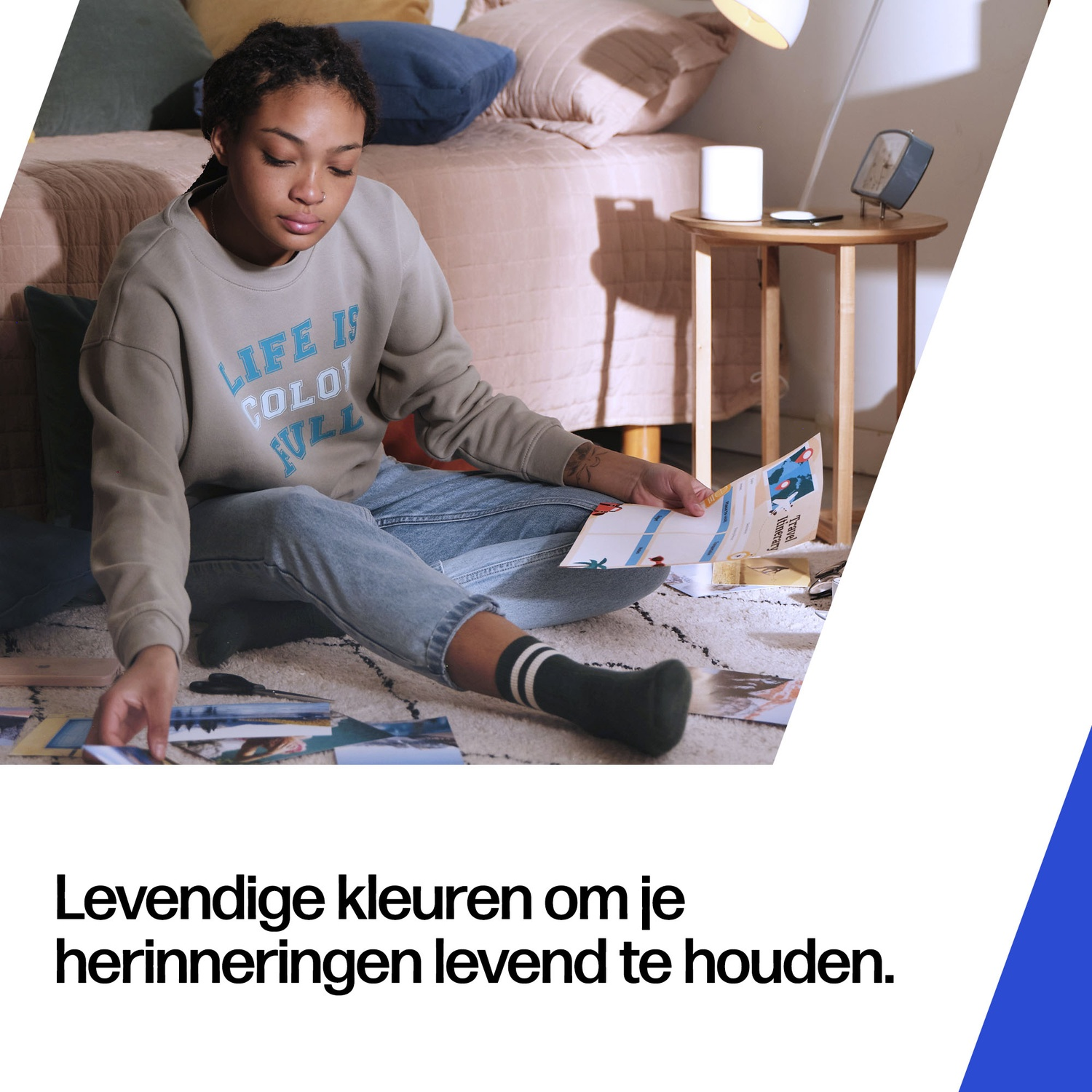 Young woman sorts photos on floor in front of a bed.