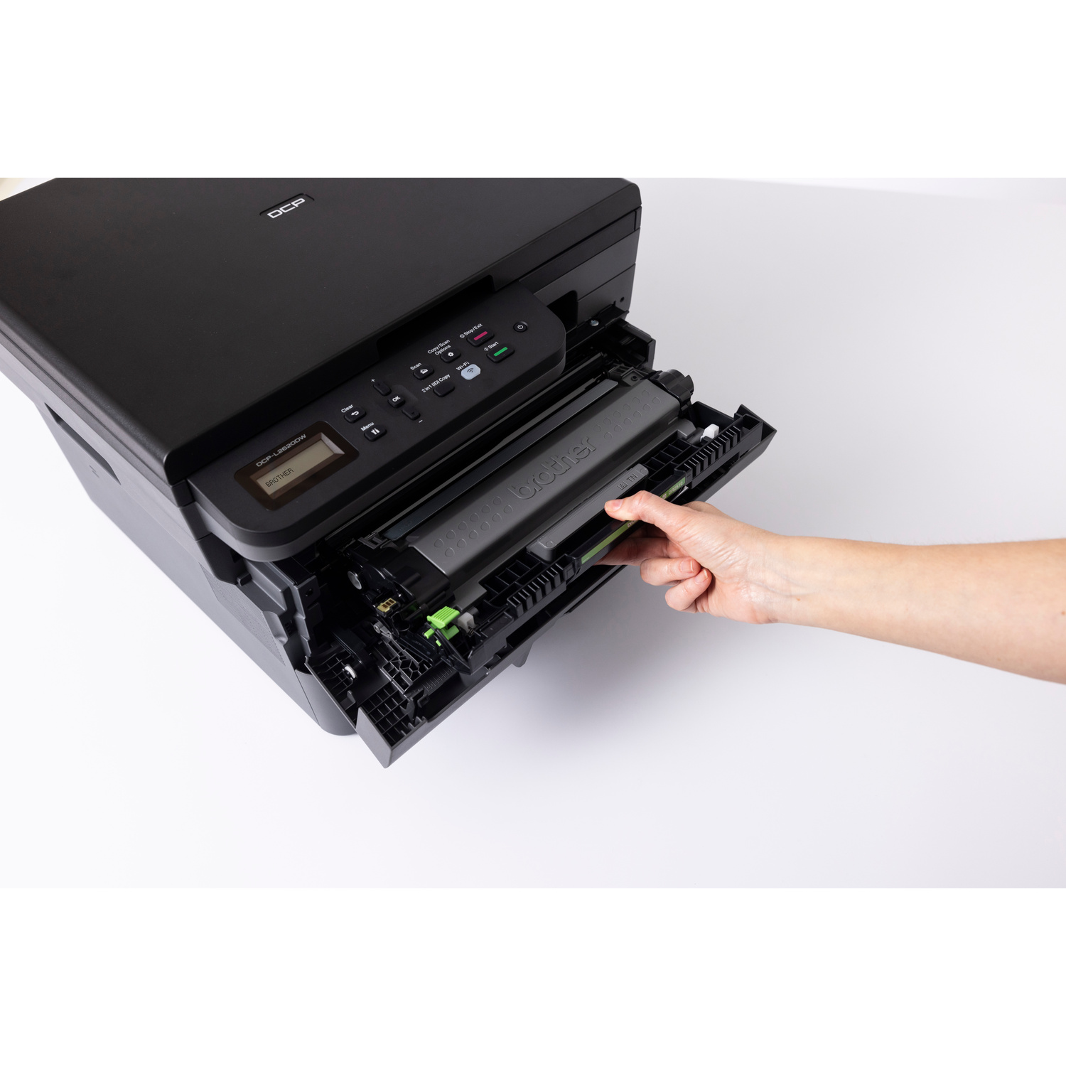 Una mano inserisce una cartuccia toner Brother nera in una stampante DCP nera.