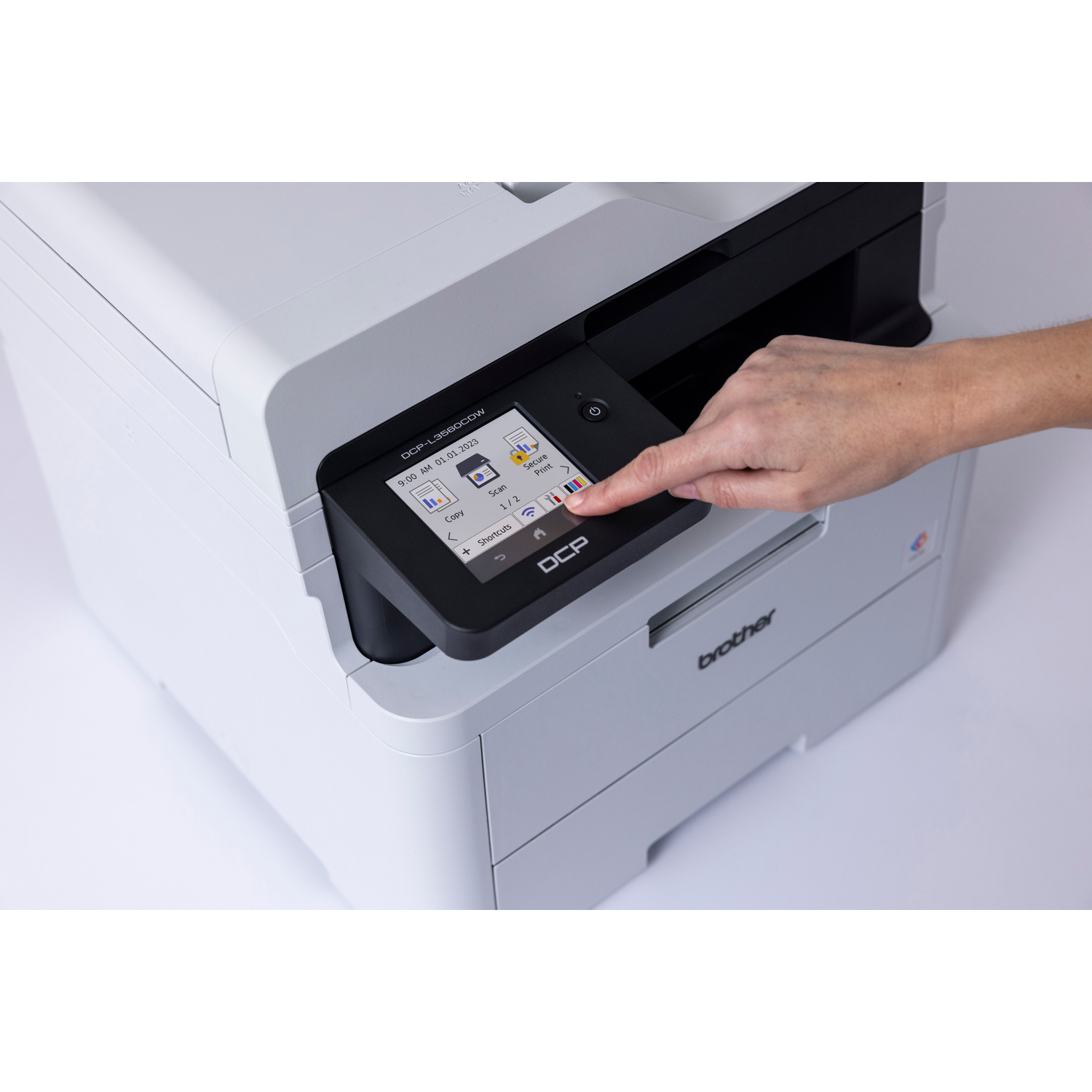 Una mano tocca lo schermo di una stampante Brother DCP-L3560CDW. Le opzioni mostrate sono Copia, Scansione, Stampa Sicura.