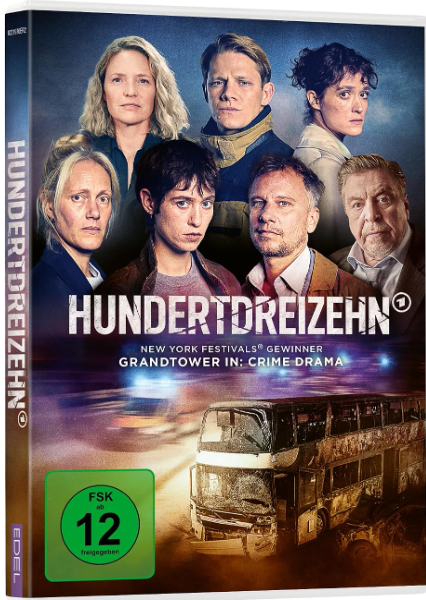 Sechs Personen blicken ernst in die Kamera vor einem ausgebrannten Doppeldeckerbus.