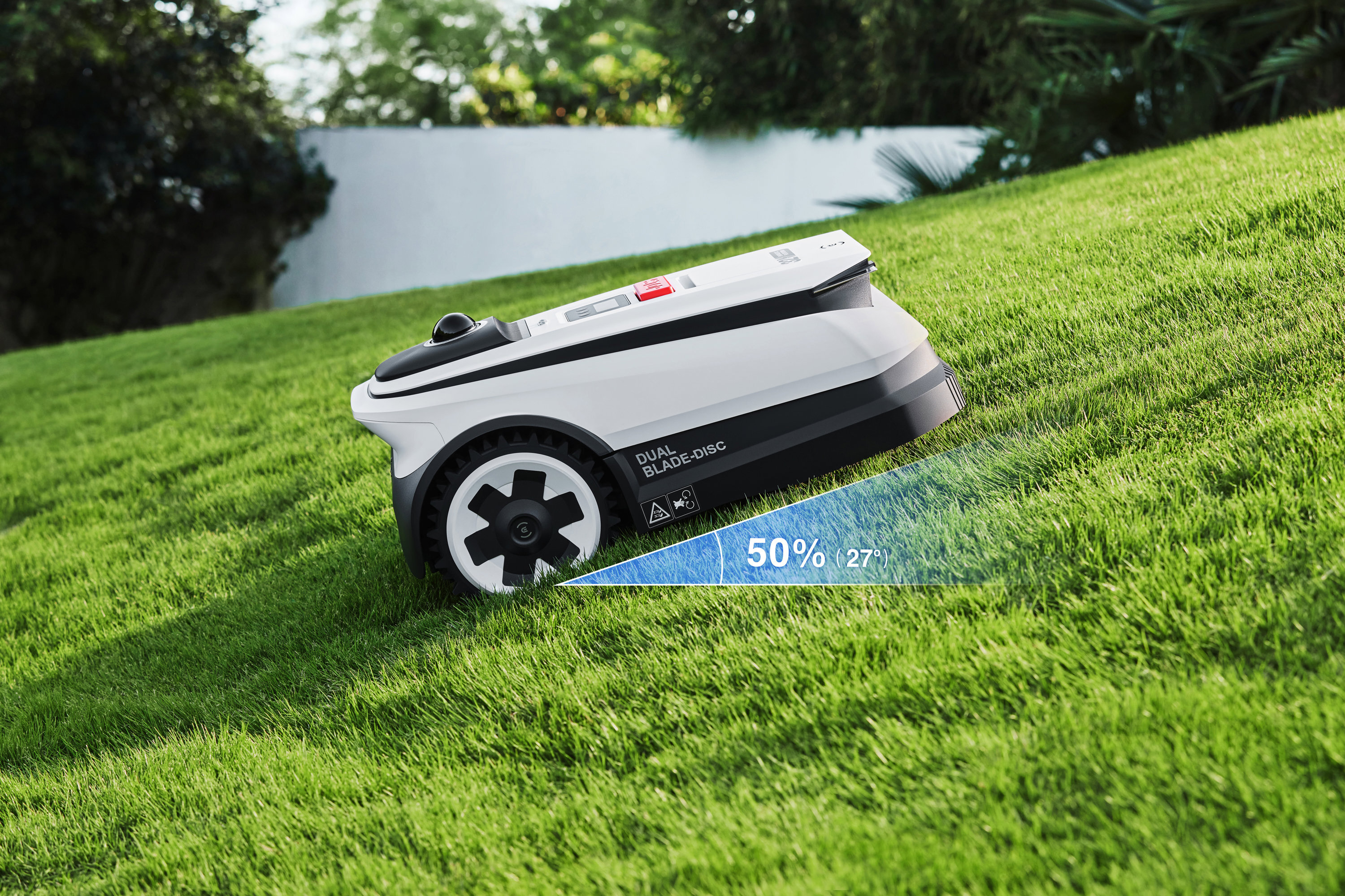 Biały robot koszący na zielonym trawniku z niebieskim wskaźnikiem pokazującym 50% (27°).
