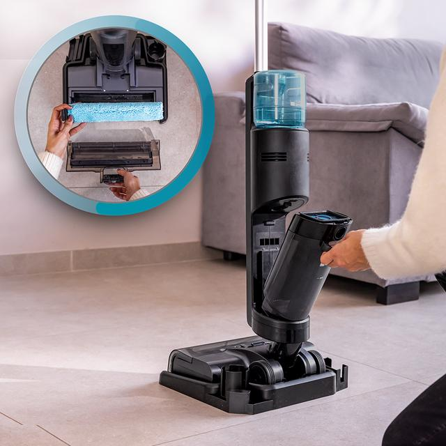 Bir kişi elektrikli süpürgenin mavi fırçasını değiştiriyor.
