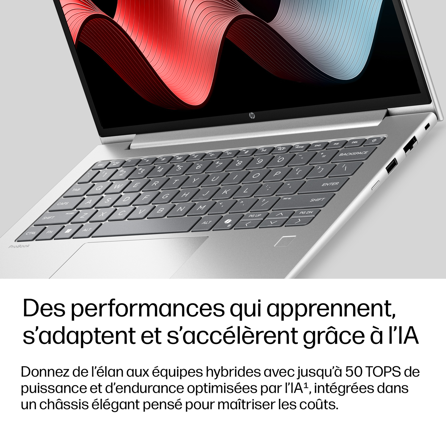 Un ordinateur portable argenté avec écran et clavier allumés.