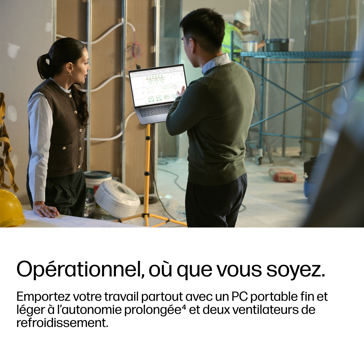 Ouvriers du bâtiment discutent des plans sur un ordinateur portable.