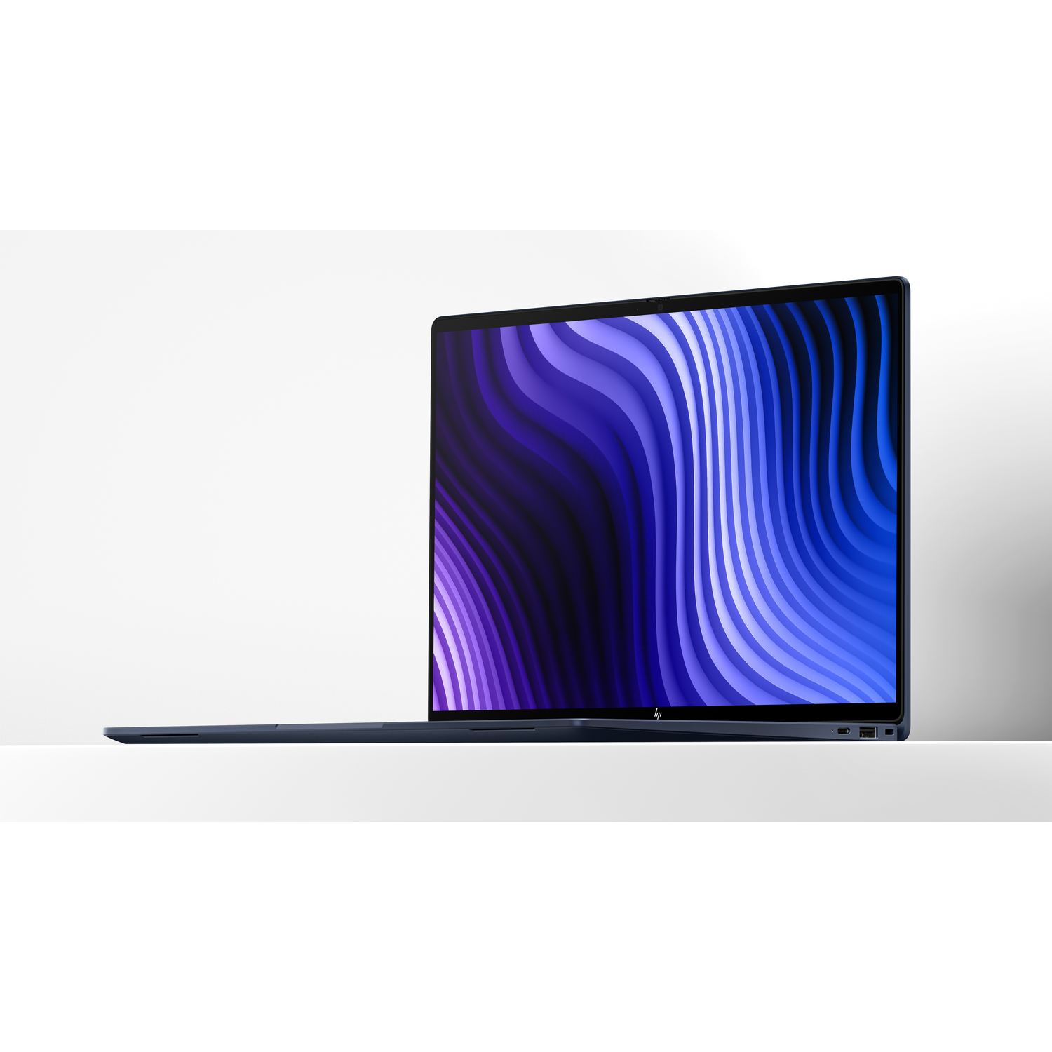 Een slanke, donkerblauwe laptop met een levendige, golvende achtergrond op het scherm.