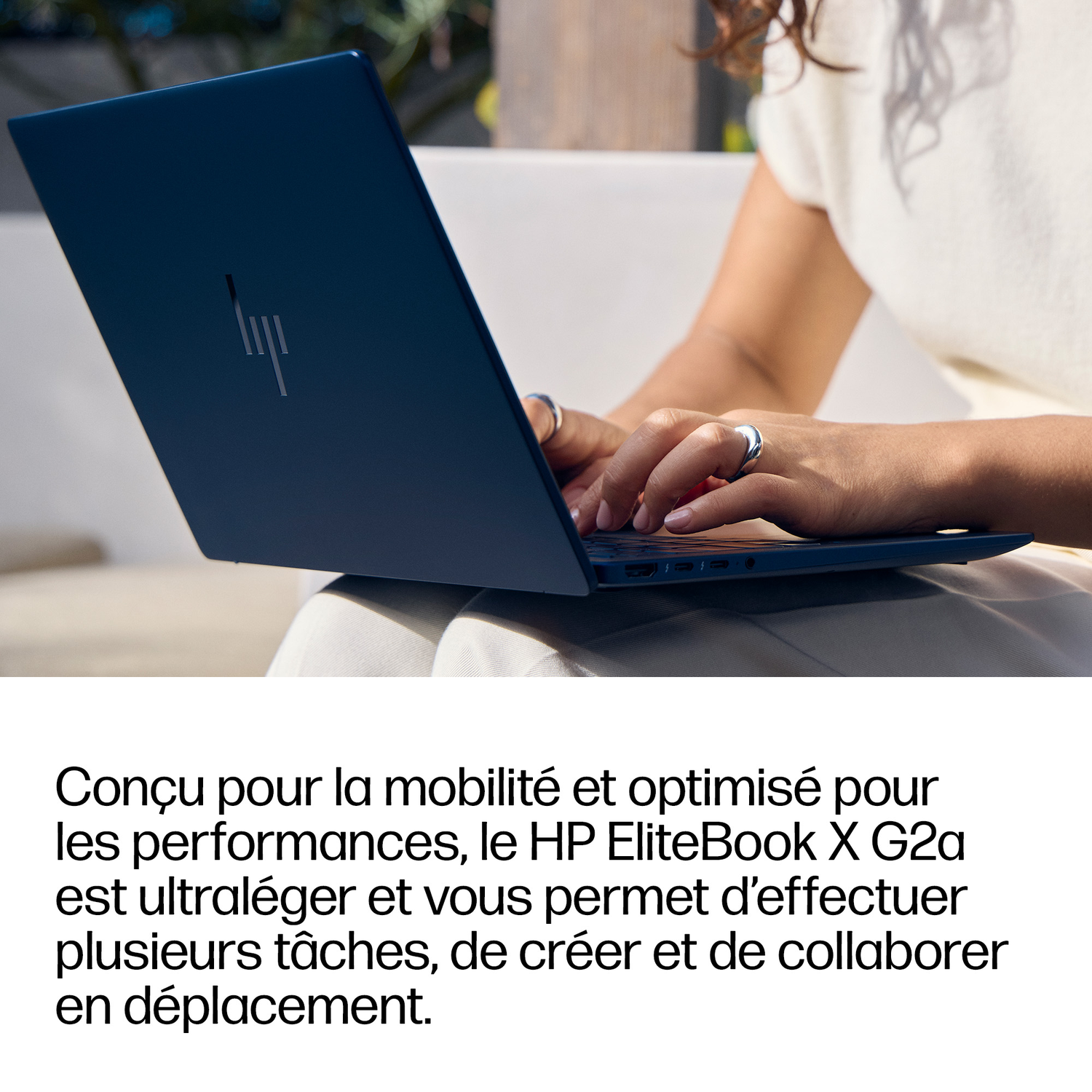 Une personne tape sur un ordinateur portable HP bleu foncé avec le logo HP.