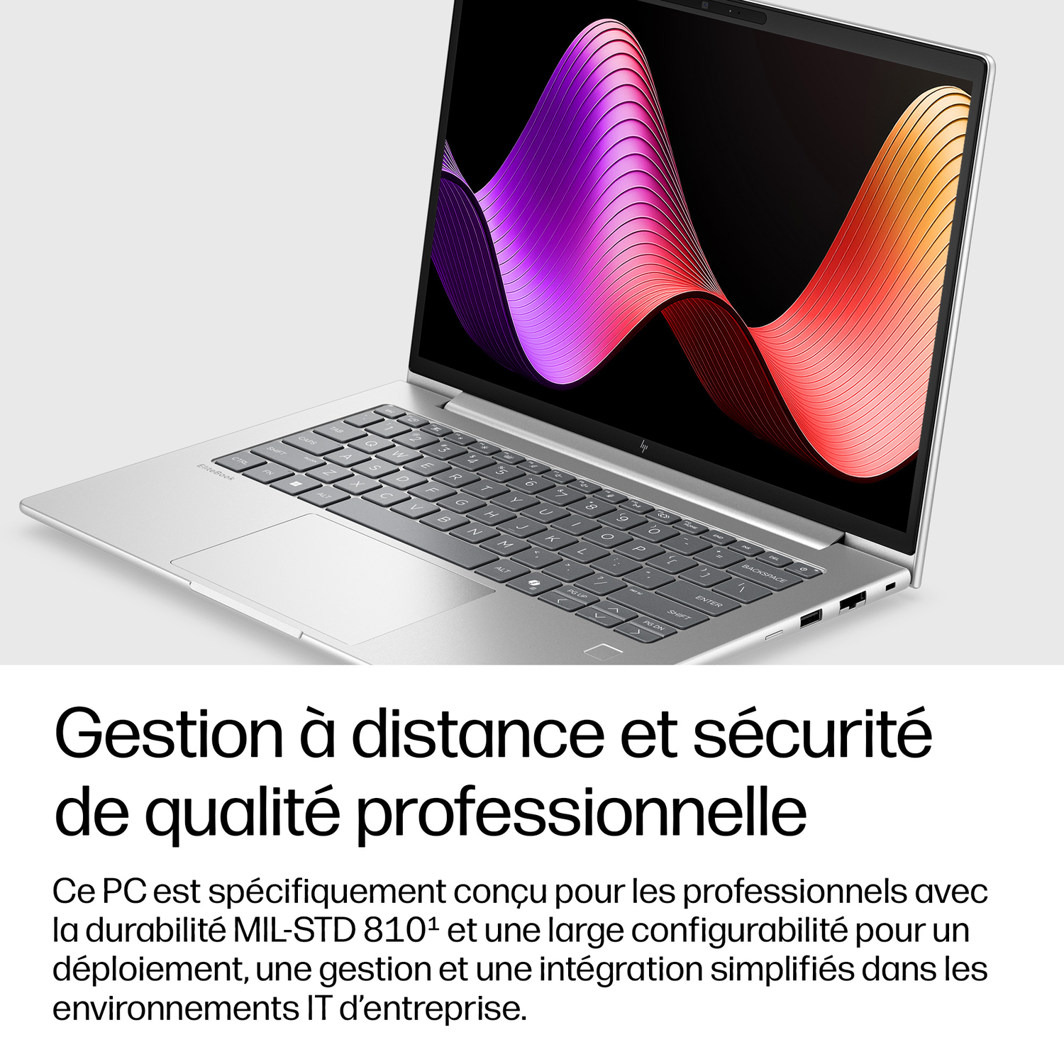 Un ordinateur portable argenté avec un motif ondulé coloré sur l'écran.