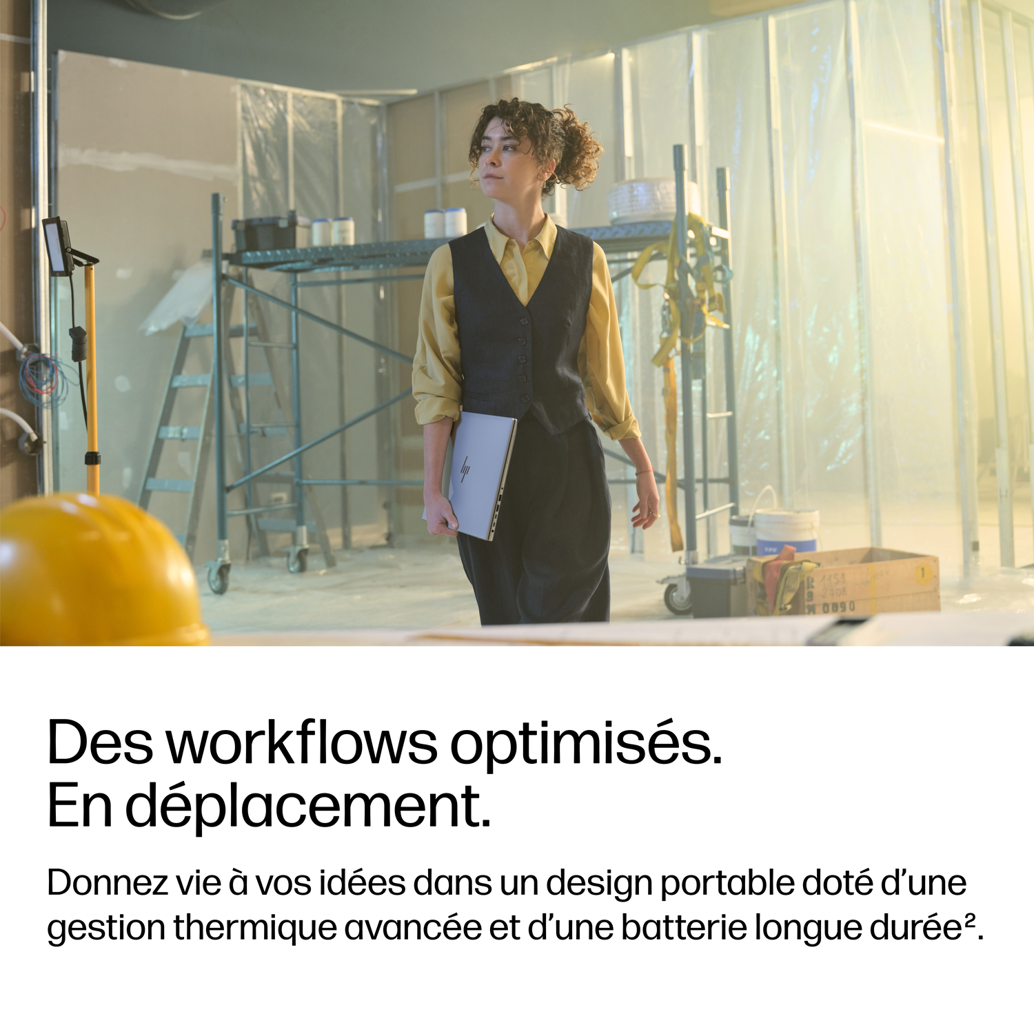 Une femme avec un ordinateur portable sur un chantier.