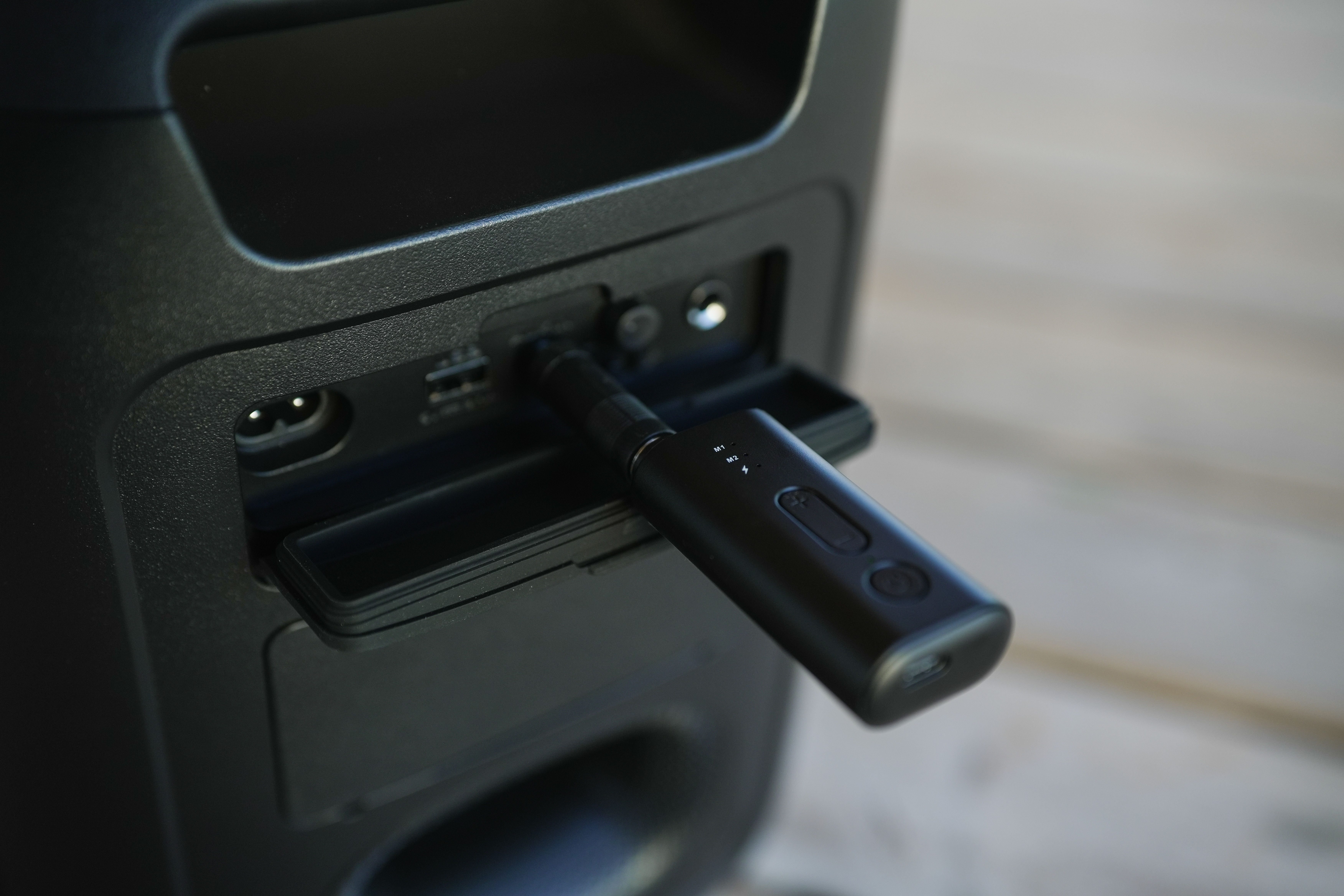 Une clé USB noire est branchée sur un haut-parleur.
