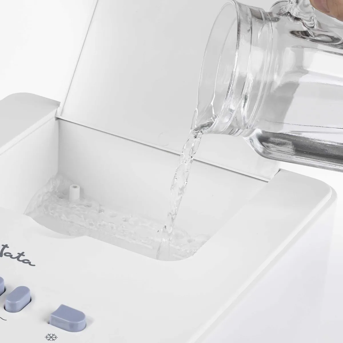 Se vierte agua de una jarra en un aparato blanco.