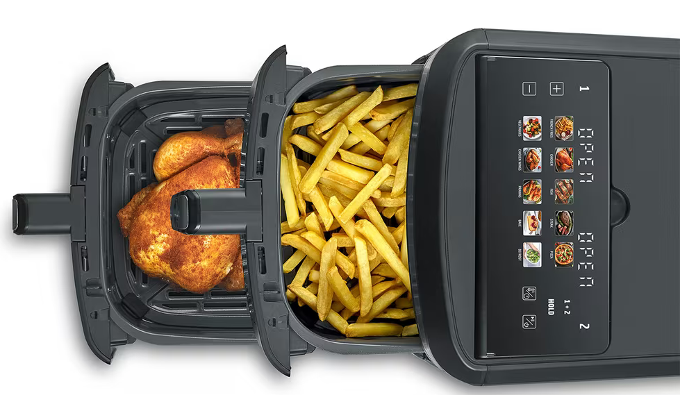 Ein Brathähnchen und Pommes frites in einem schwarzen Heißluftfritteusen-Korb.