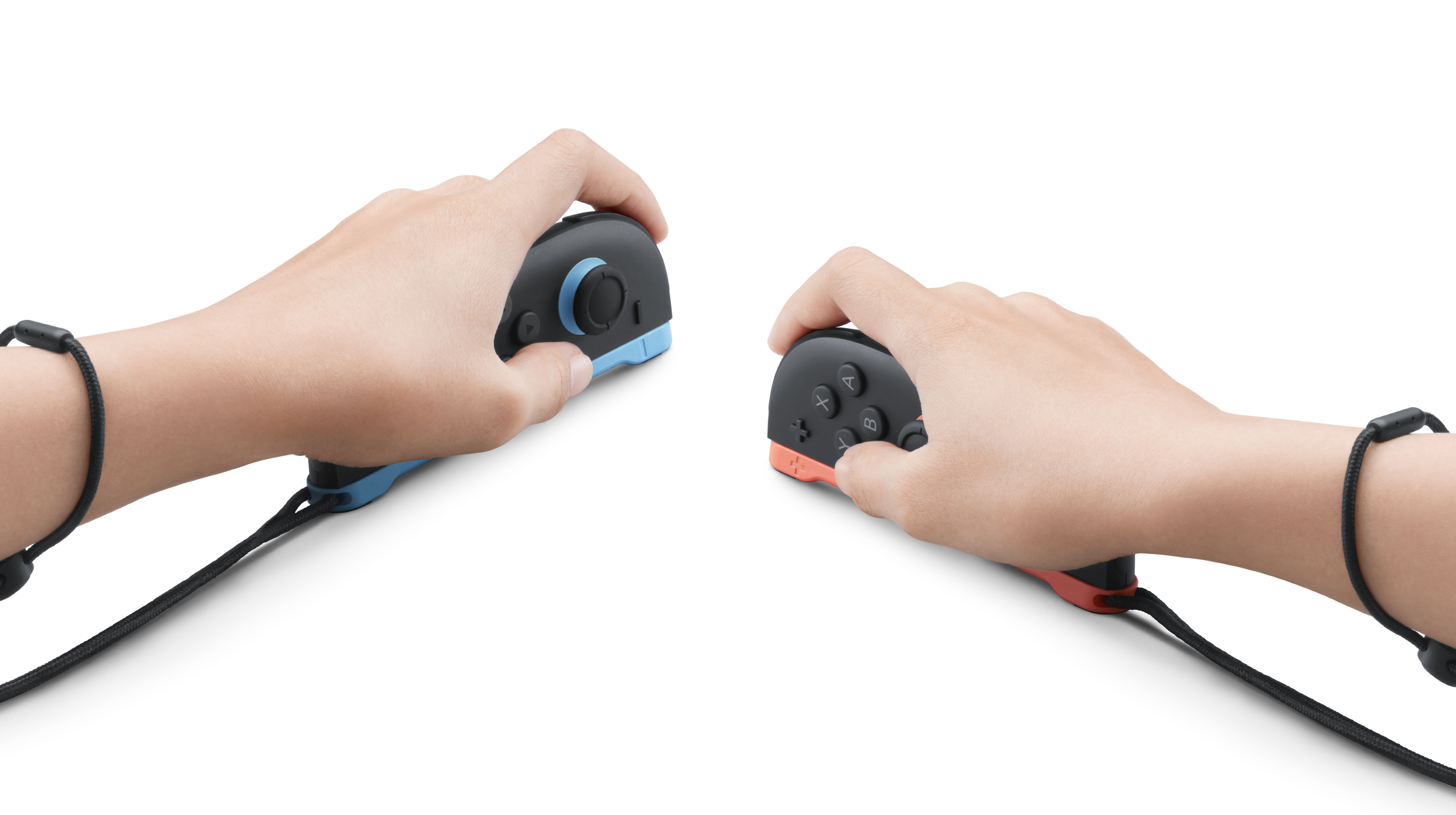 İki el Joy-Con kontrolcüsünü tutuyor, biri mavi diğeri kırmızı.