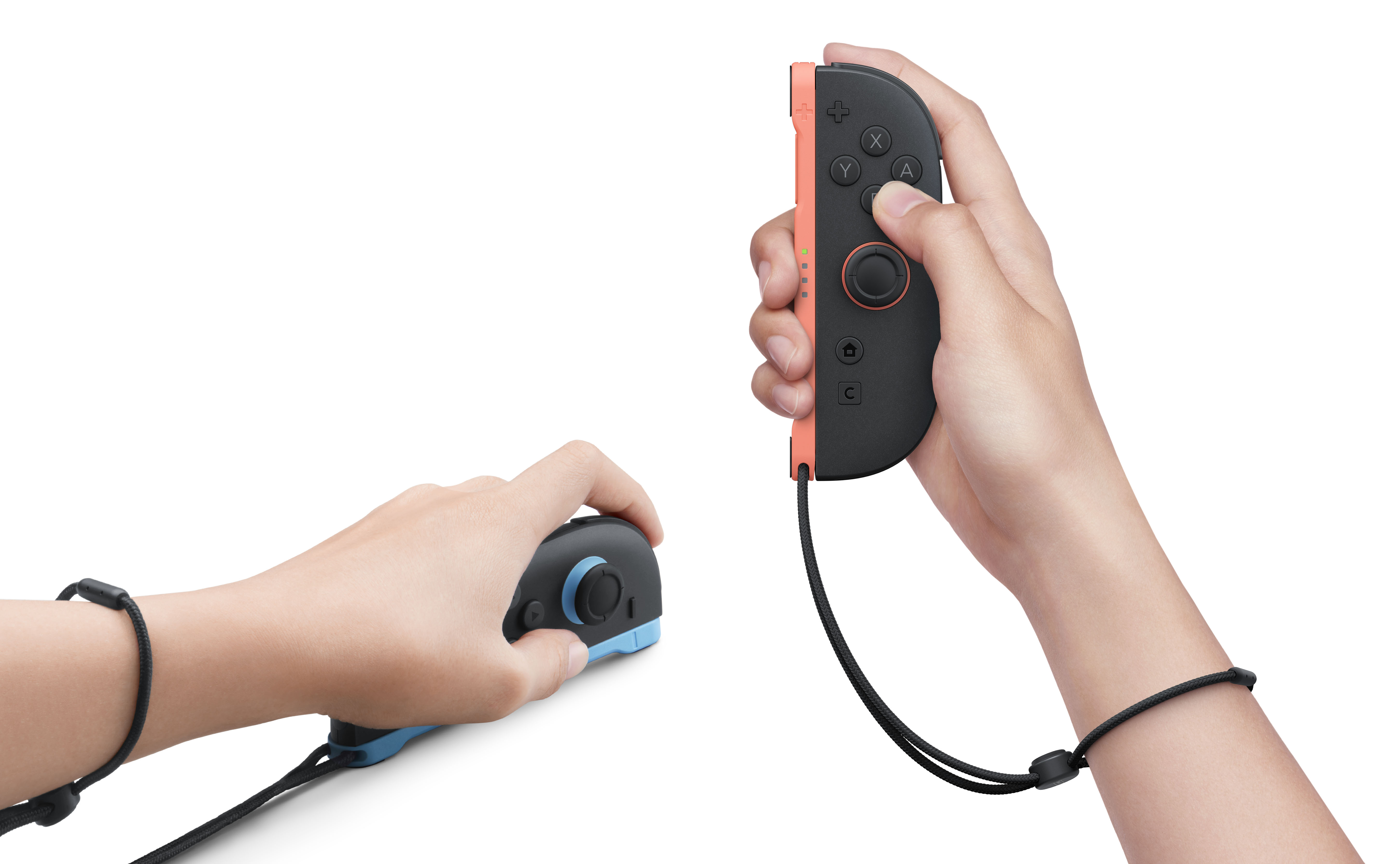 Eller siyah/turuncu ve siyah/mavi Nintendo Switch Joy-Con kontrolcüler tutuyor.