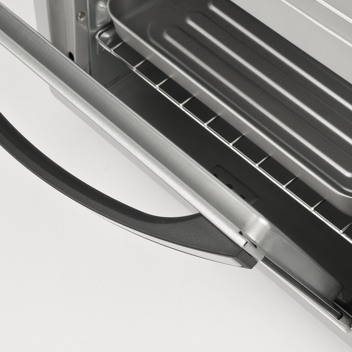 Primo piano di un forno aperto con maniglia argentata e teglia all'interno.