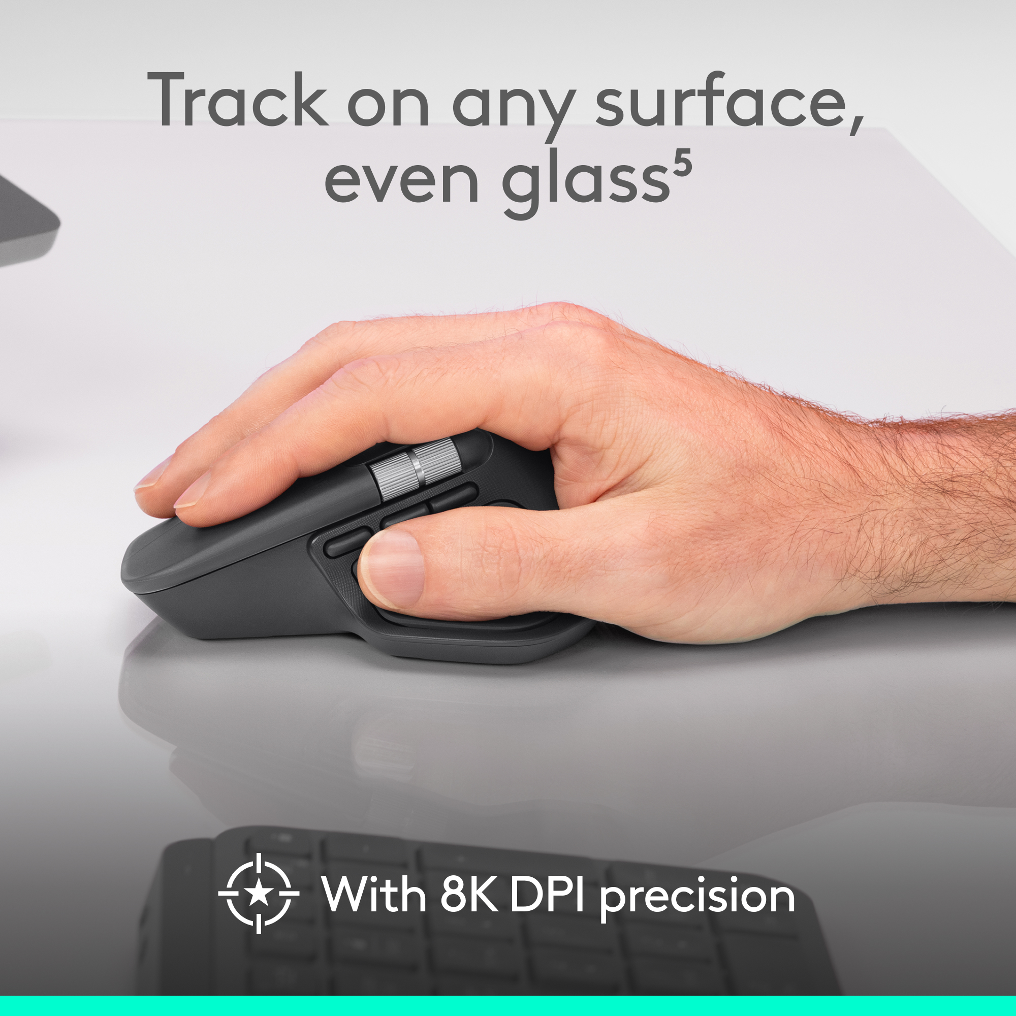 Main utilisant une souris sombre avec molette sur une surface lisse.