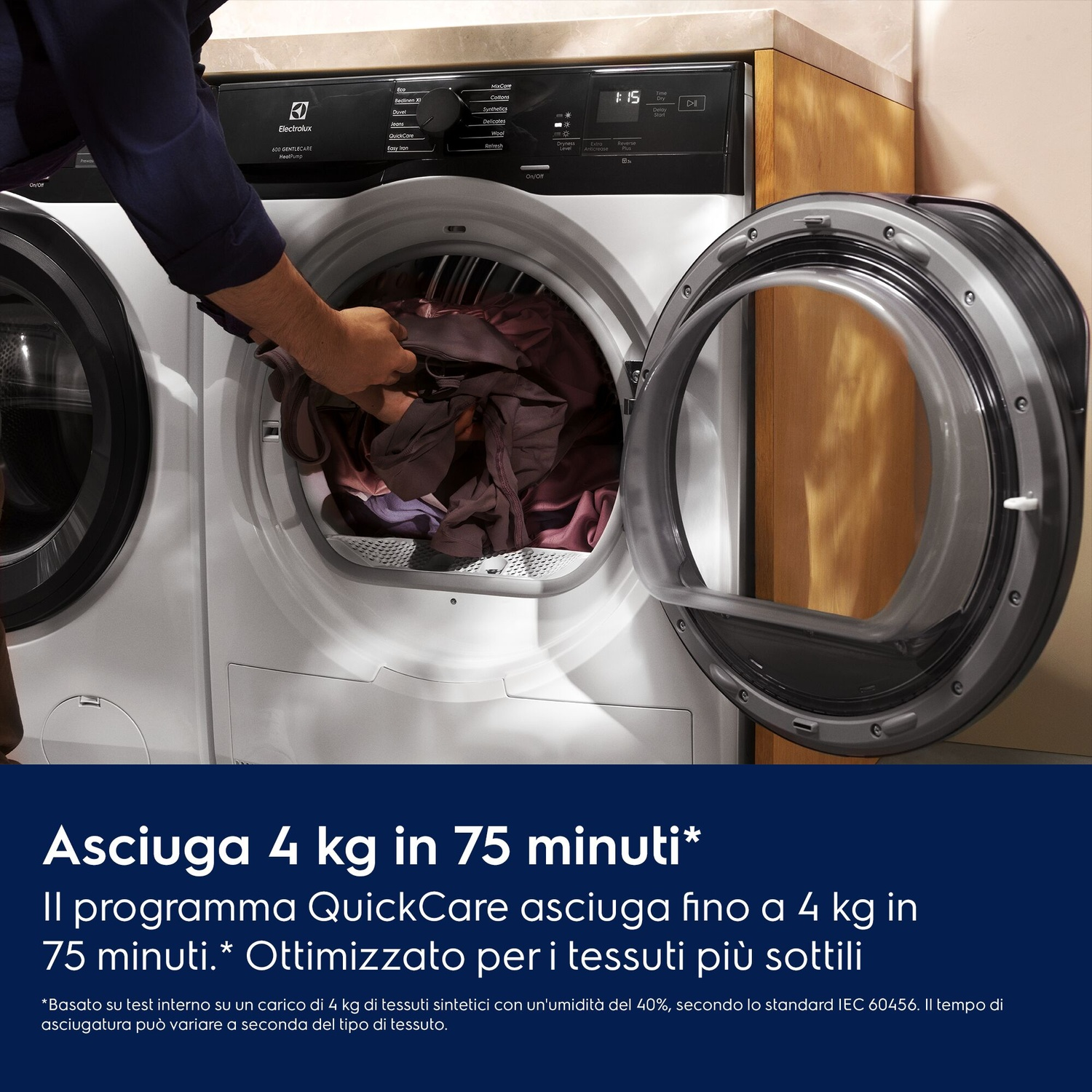 Uomo carica vestiti nell'asciugatrice. Porta aperta. Display mostra 1:15.