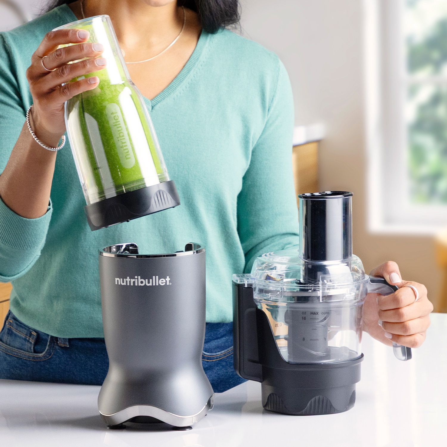 Una donna tiene una tazza Nutribullet con frullato verde.