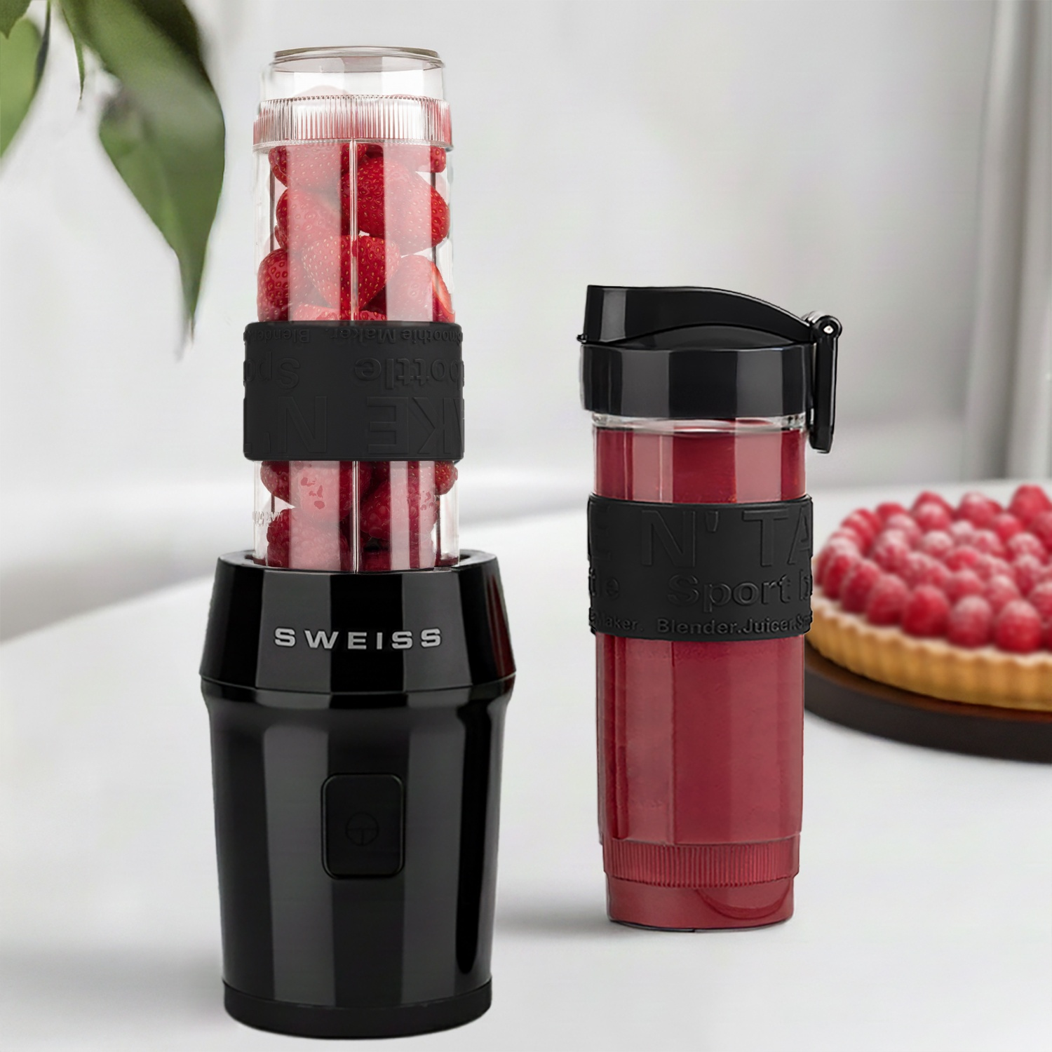 Due frullatori portatili con frutta e una crostata di frutta sullo sfondo.