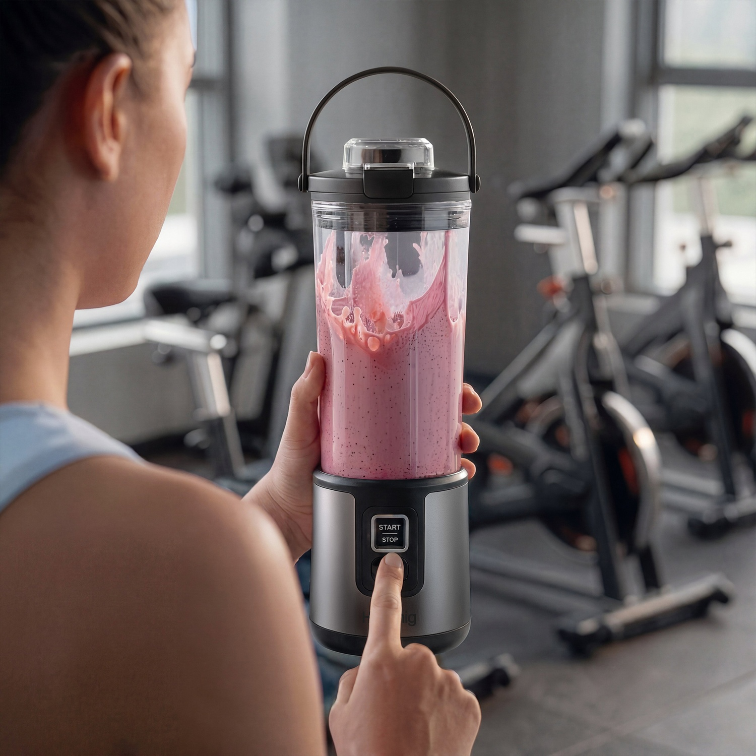 Donna frulla frullato rosa in palestra con cyclette.