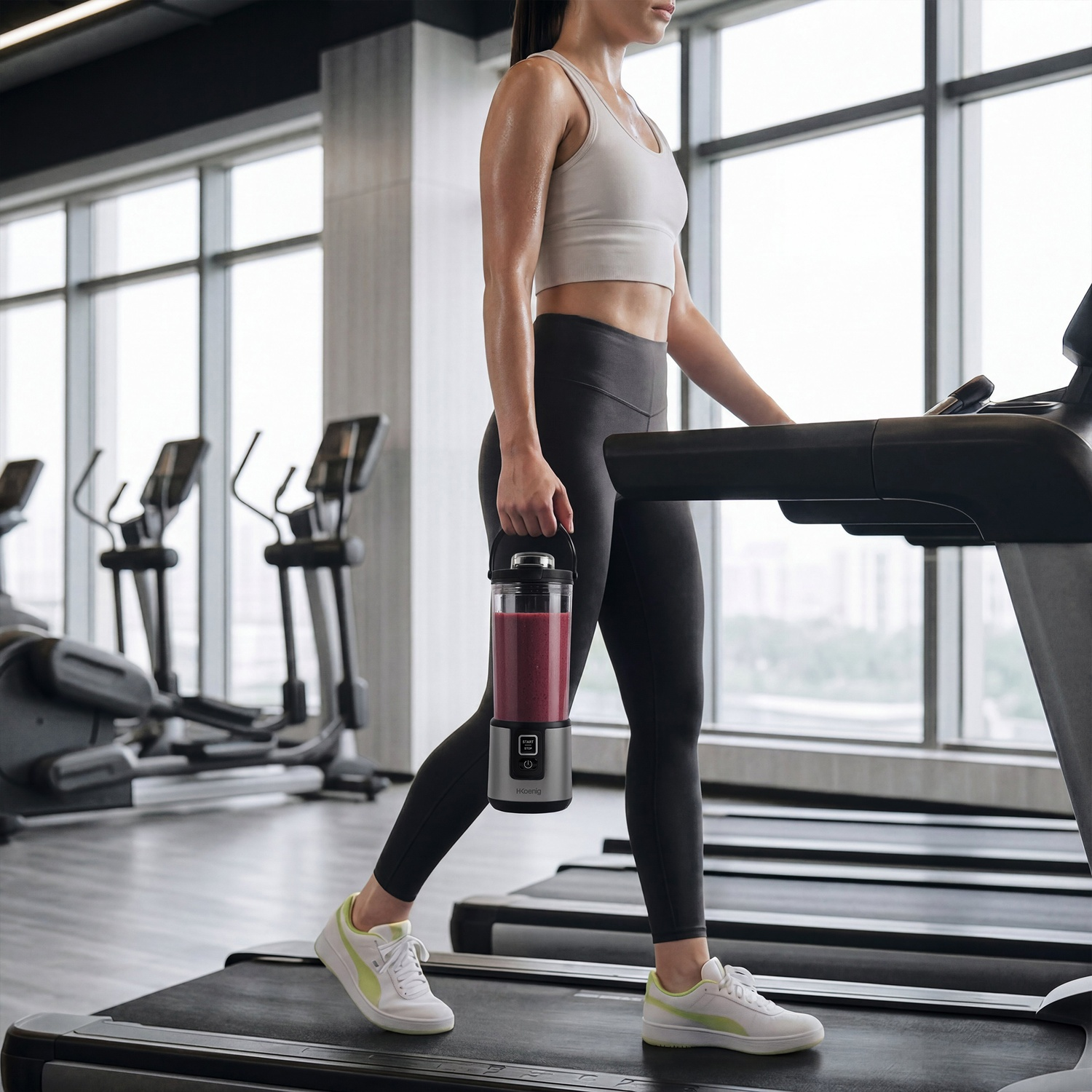Donna con frullatore portatile cammina su un tapis roulant in palestra.