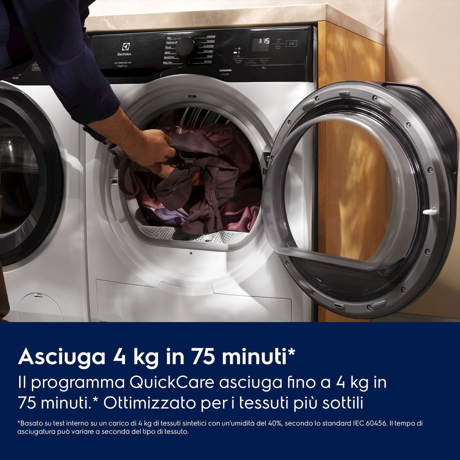 Uomo carica asciugatrice con biancheria scura. Porta socchiusa.