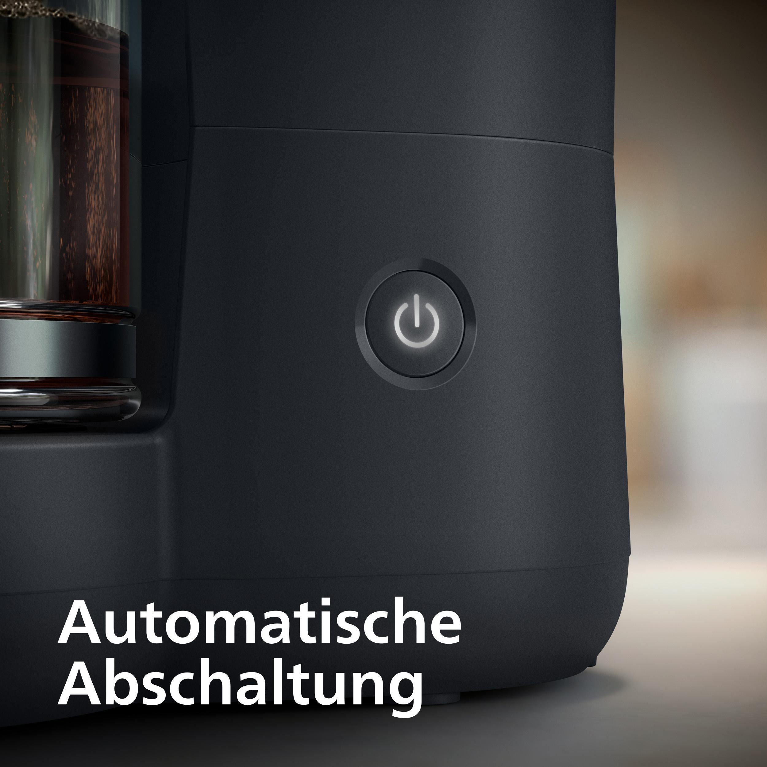 Schwarze Kaffeemaschine mit beleuchtetem Netzschalter und Glaskrug.