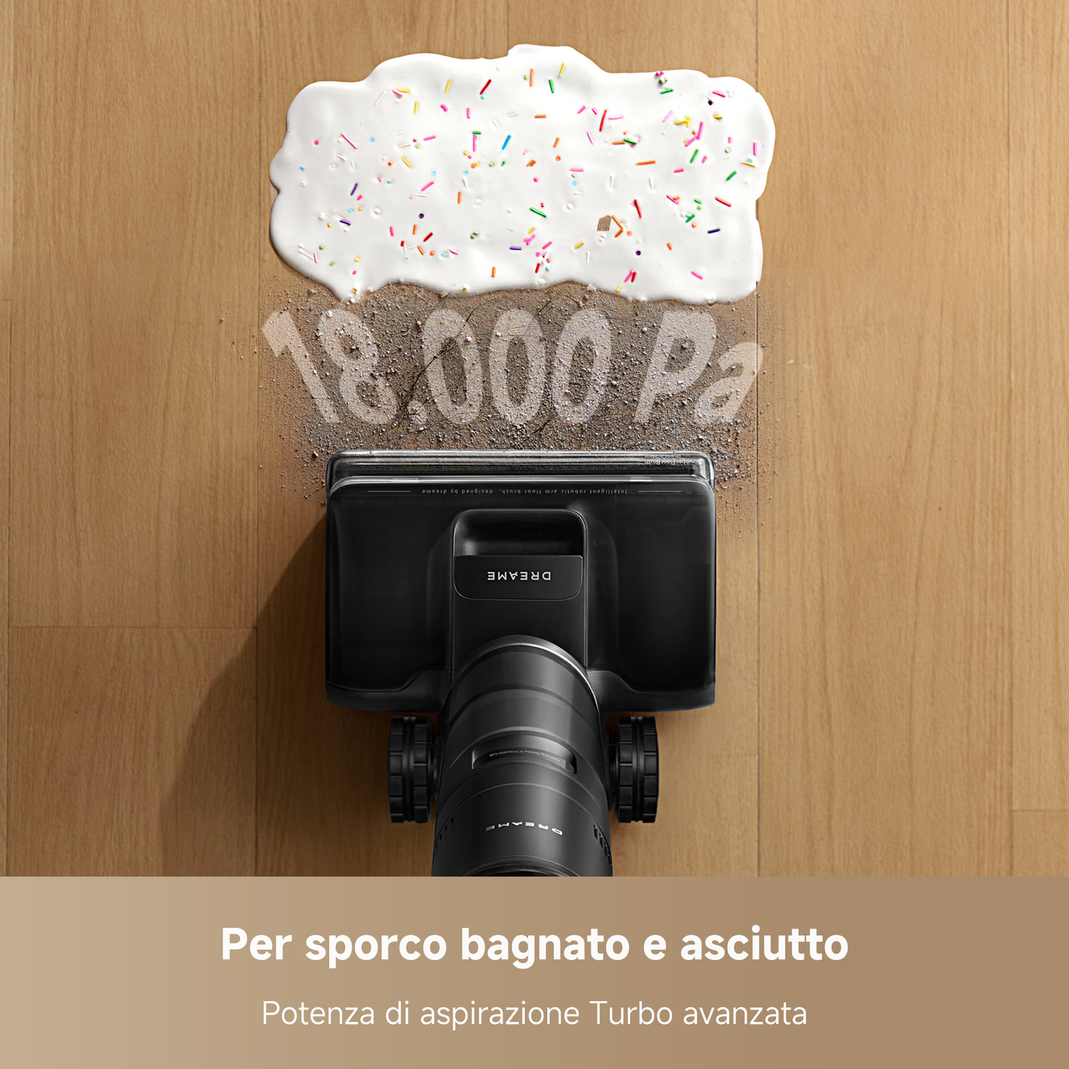Un aspirapolvere pulisce un pasticcio di glassa e codette versato su un pavimento in legno.