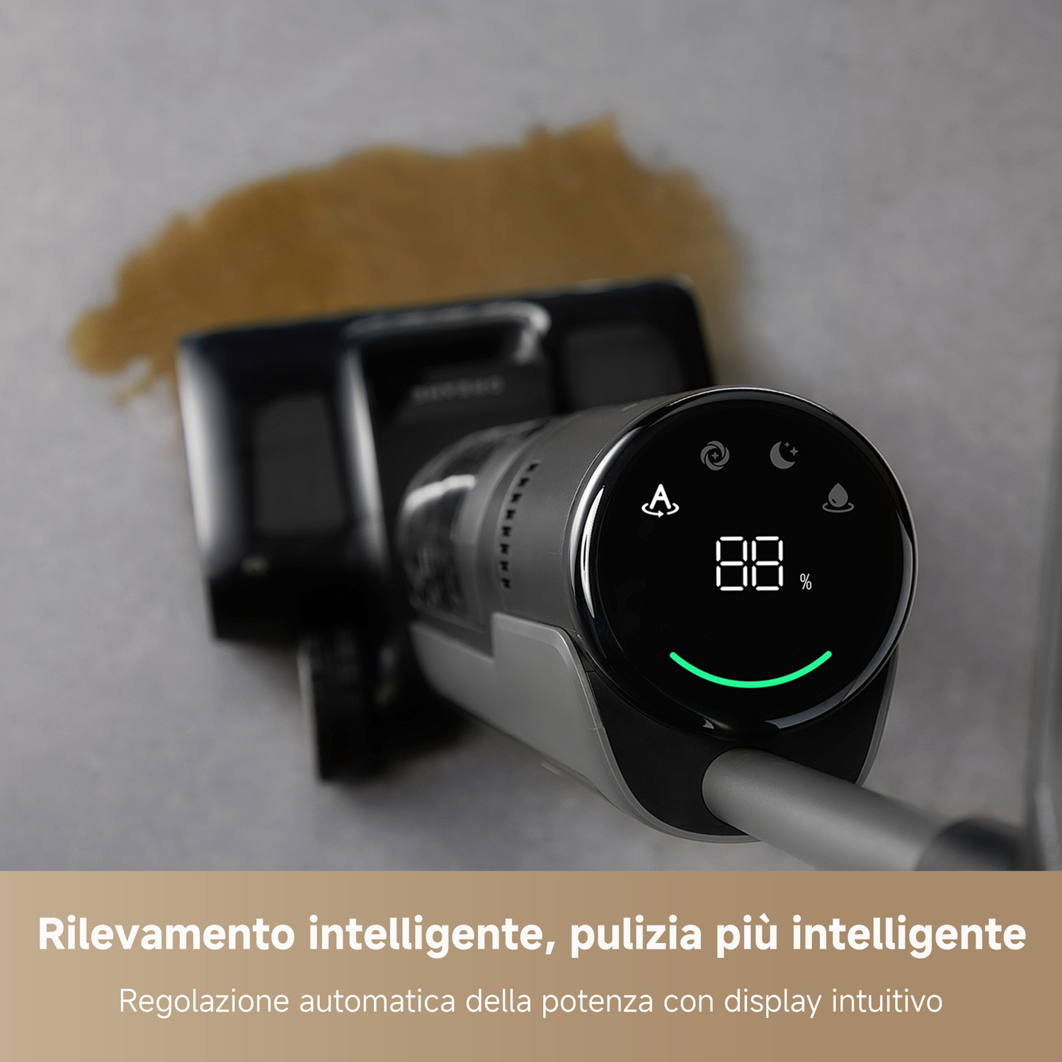 Un aspirapolvere con display digitale che mostra 88% vicino a una macchia di liquido.