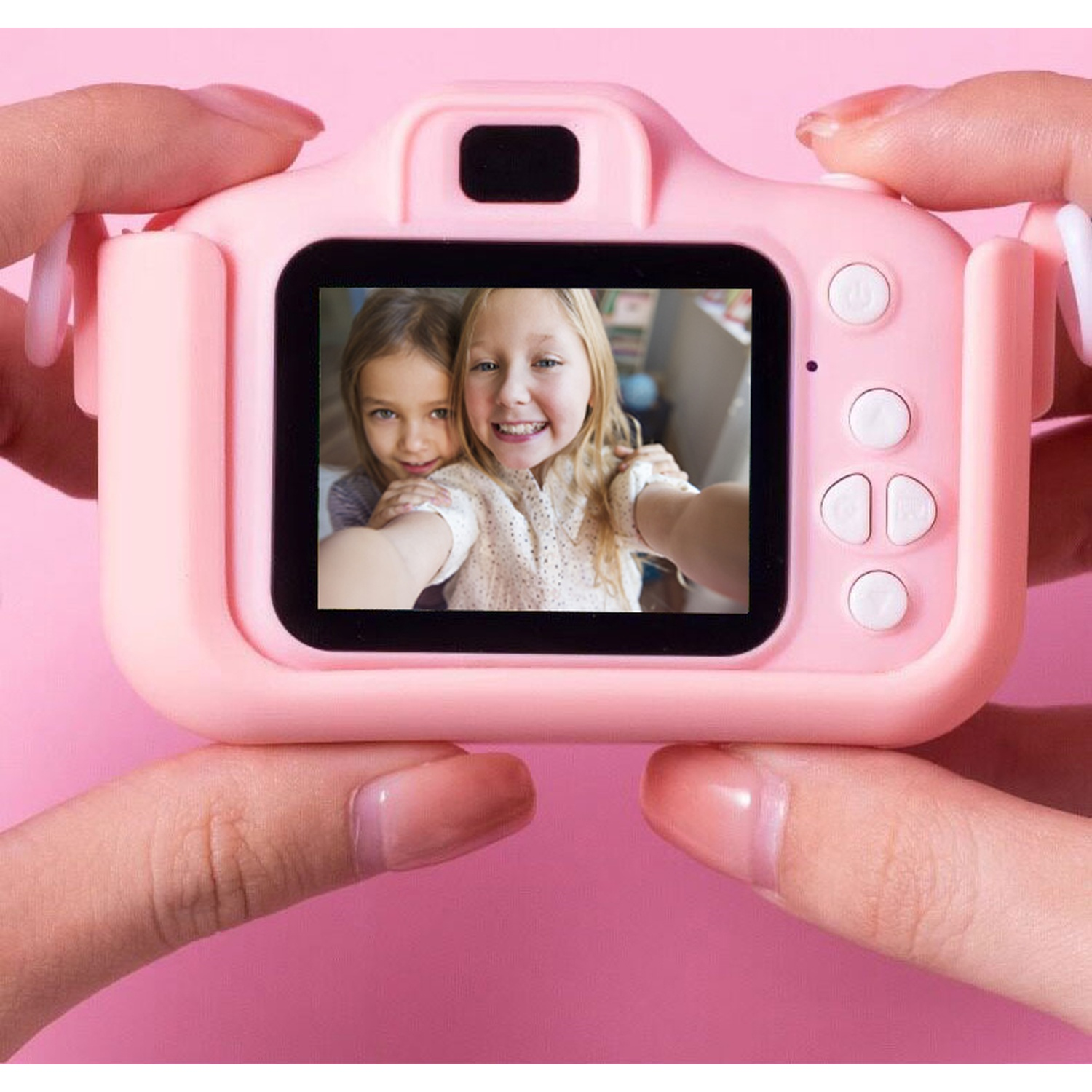Due bambine sorridono in una fotocamera rosa tenuta dalle mani.