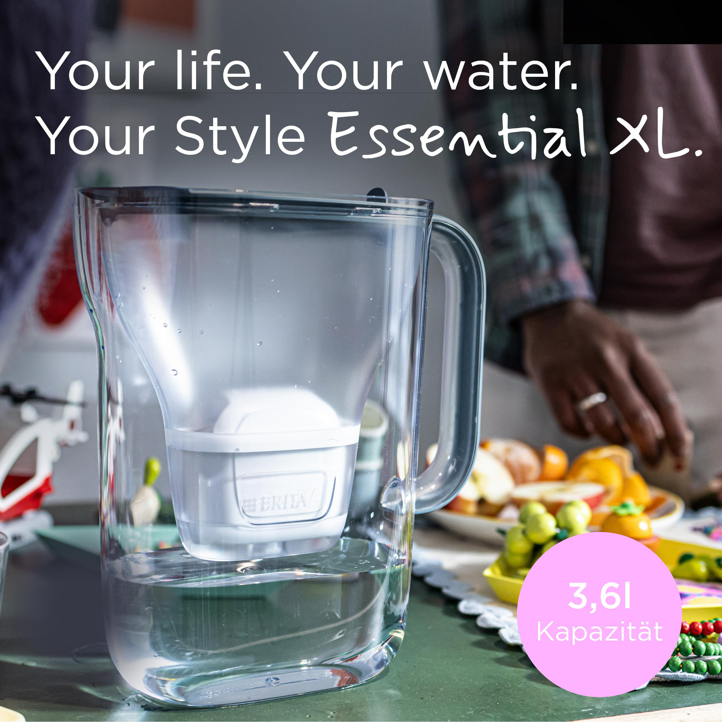 Ein Brita Wasserfilterkrug steht auf einem Tisch, neben Obst und einer Person.