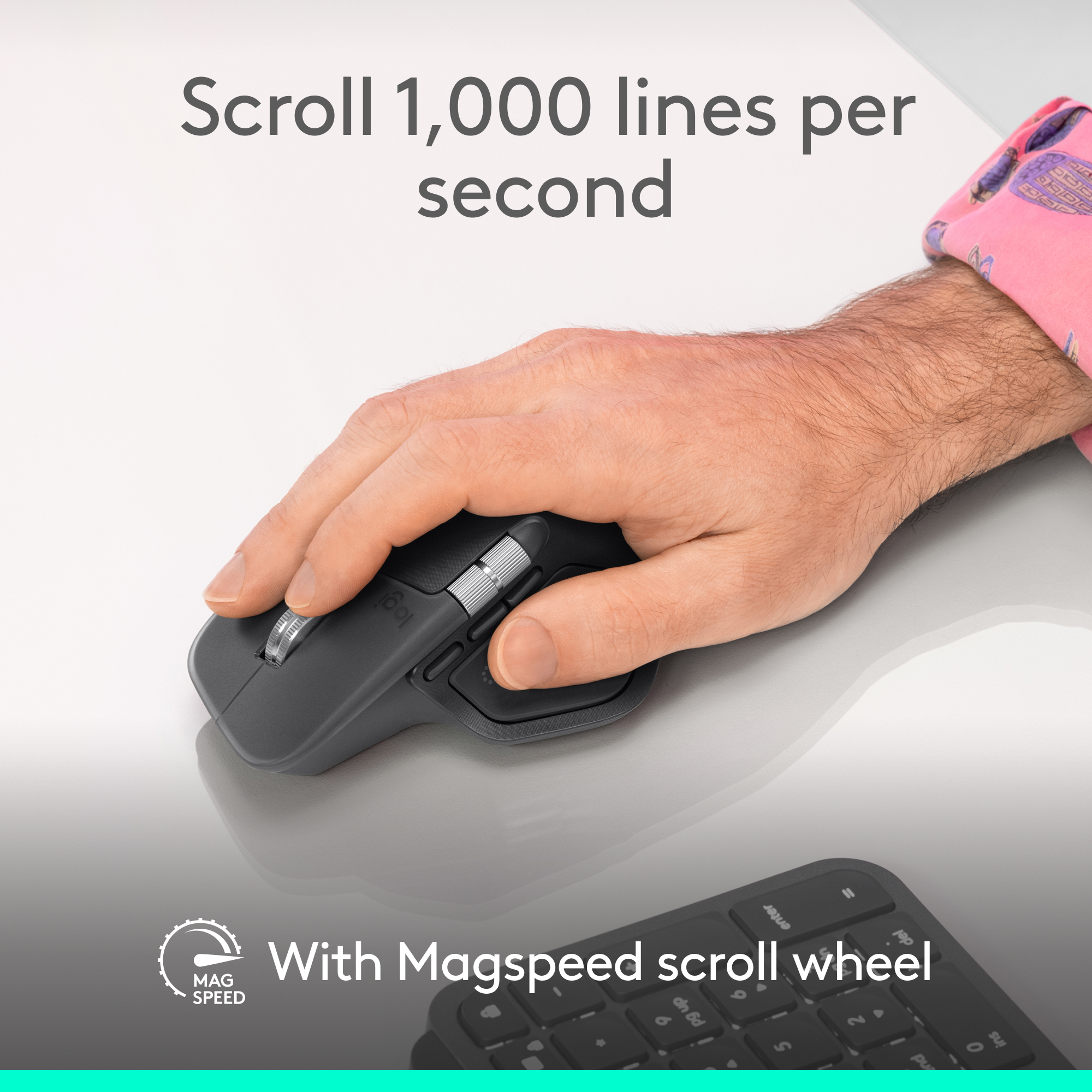 Une main utilise une souris Logitech grise avec molette MagSpeed et clavier.