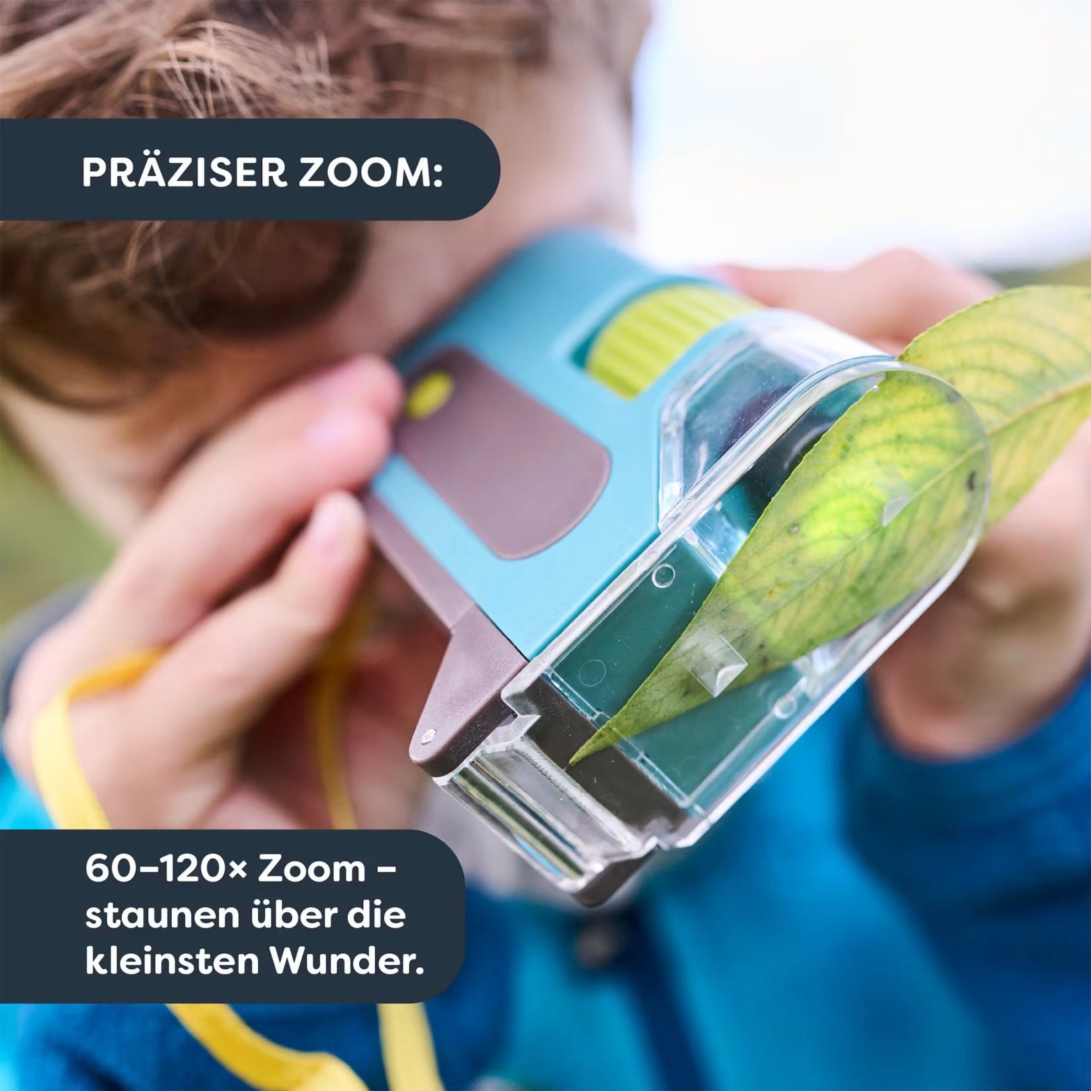 Egy gyermek kék és zöld mikroszkópon keresztül néz egy levelet.