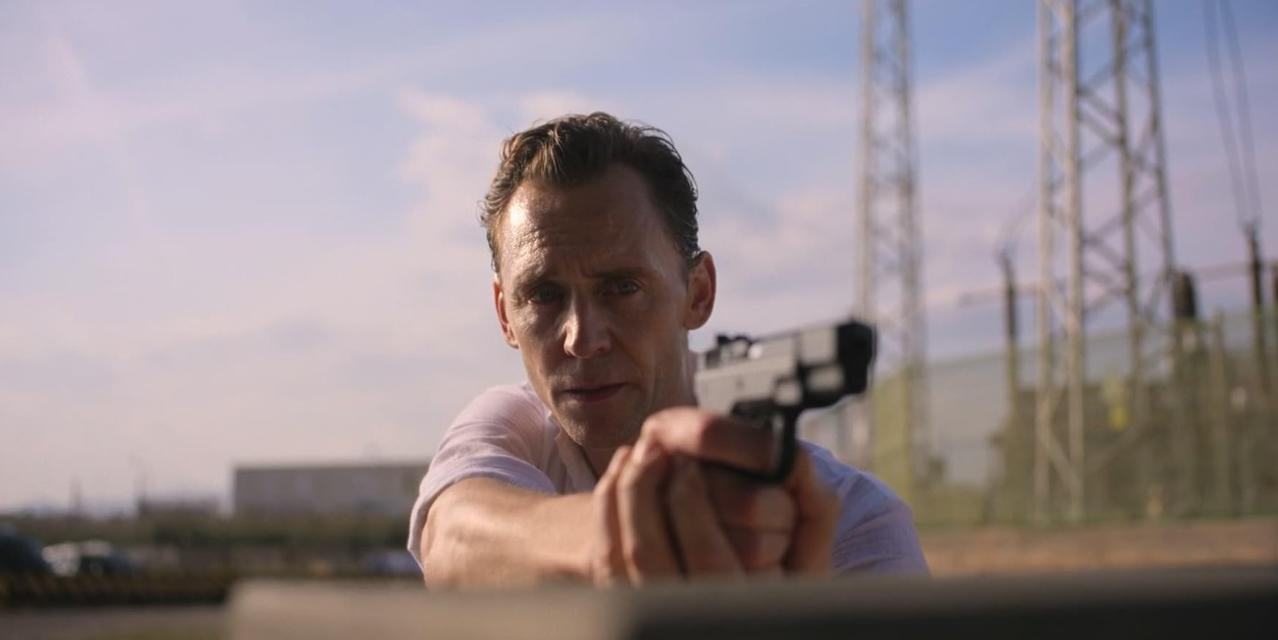 Ein Mann mit Waffe zielt nach vorne, im Hintergrund Strommasten.