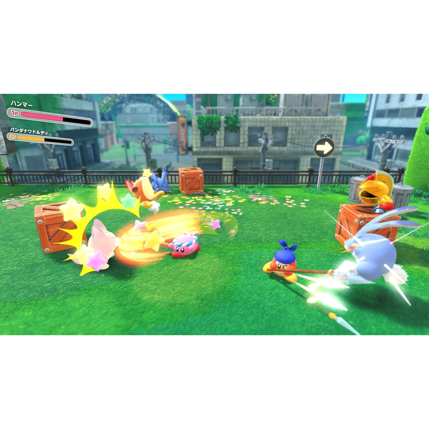 Kirby characters battle with stars and weapons on a green grassy field with buildings.