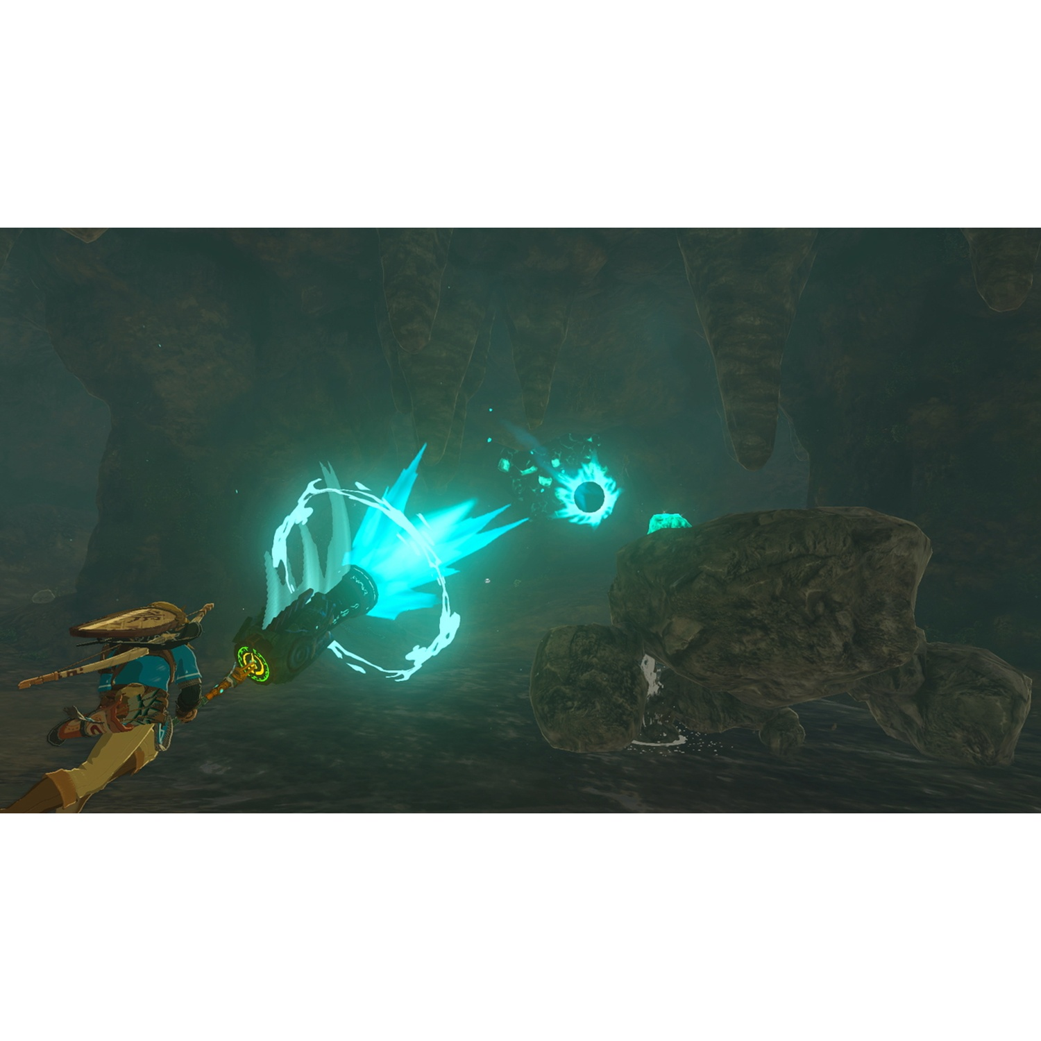 A character fires a blue energy blast at a rock in a dark cave.