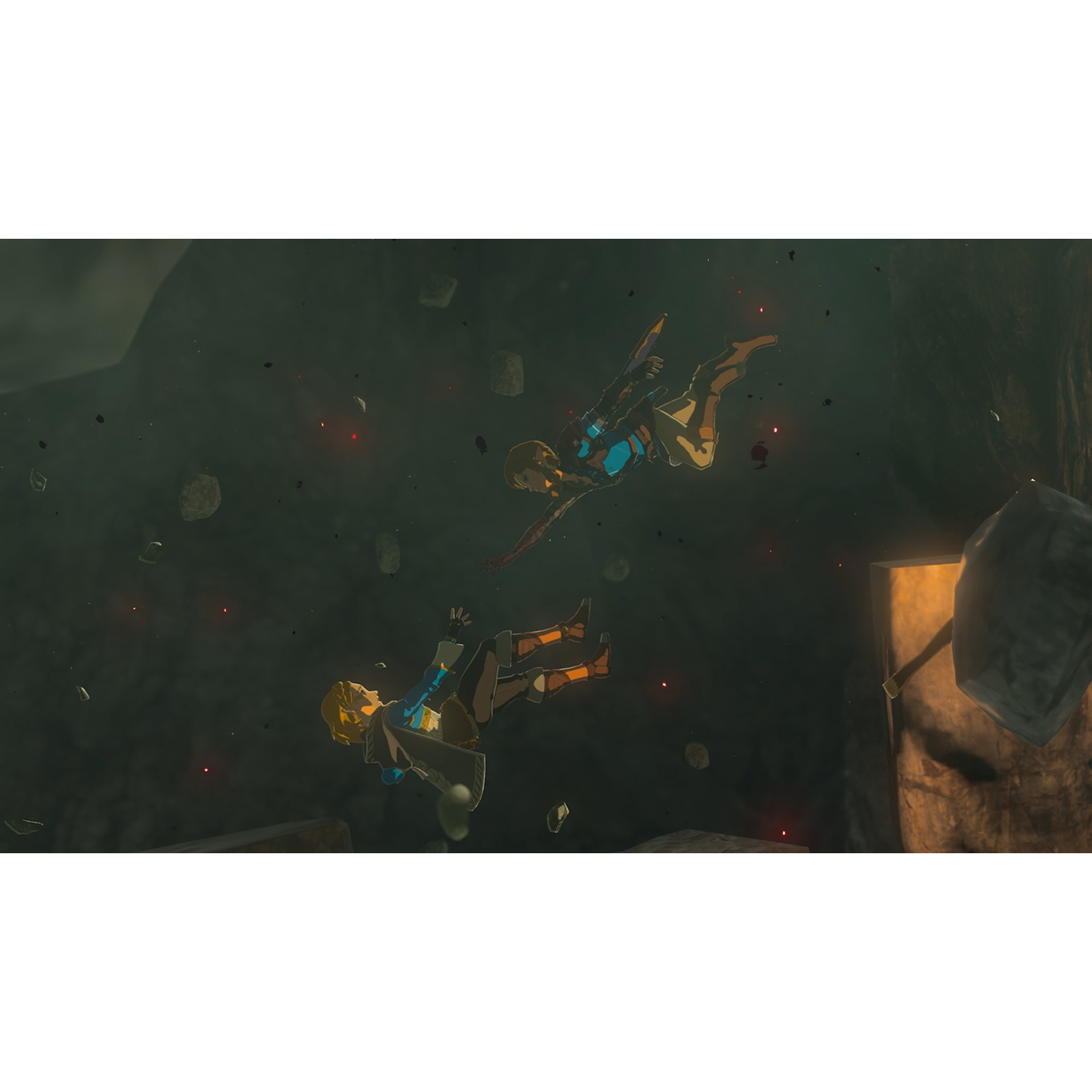 Two figures in blue and gold fall through a dark, rocky cavern with glowing red embers.