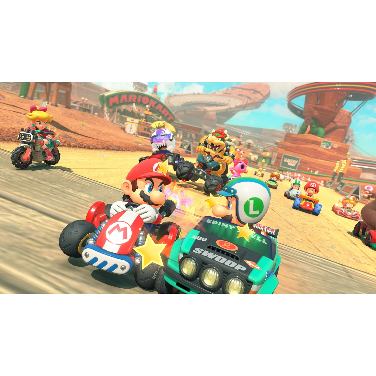 Mario Kart characters race on a desert track with Bowser and Luigi in the foreground.