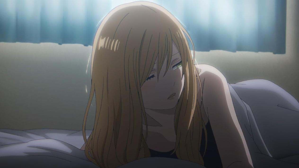 Eine junge Frau mit blonden Haaren liegt auf einem Bett, bedeckt mit einer Decke.
