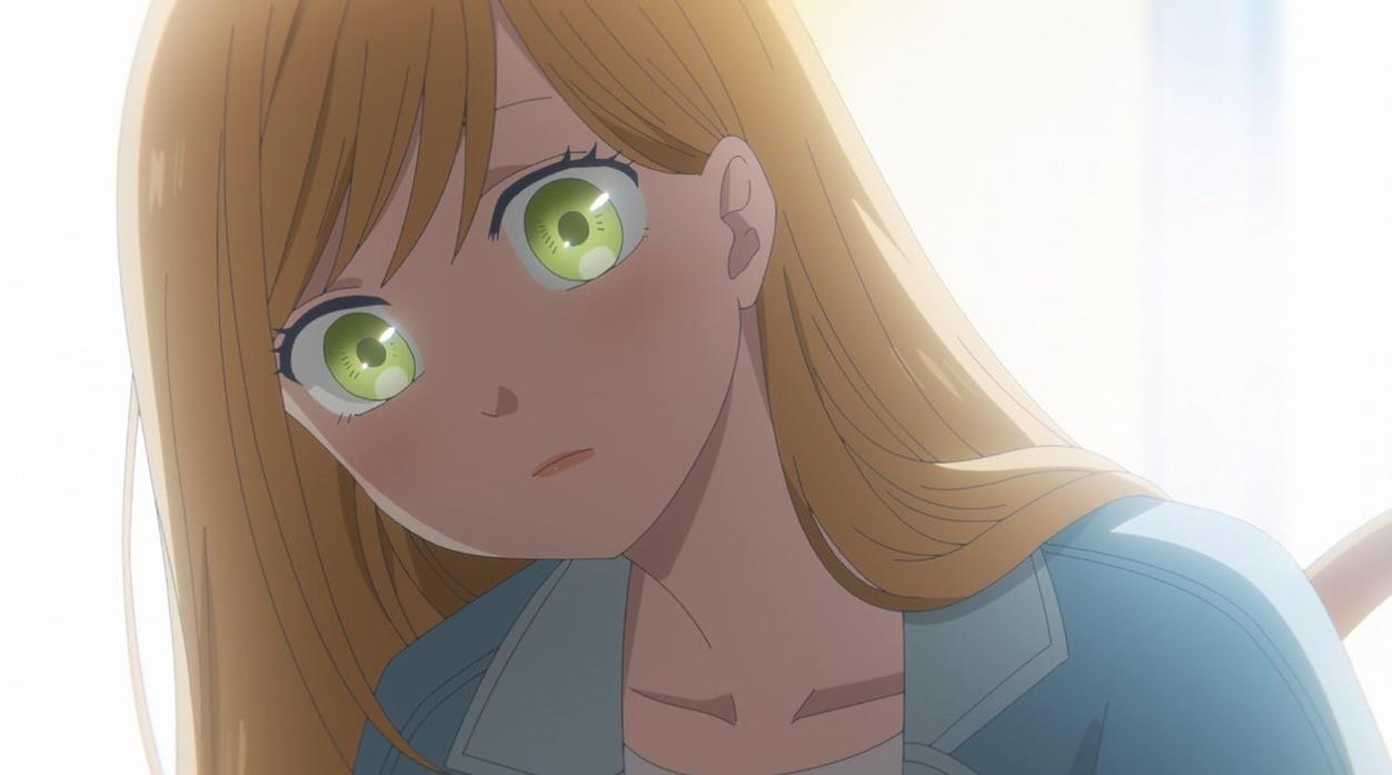 Anime-Mädchen mit blonden Haaren und grünen Augen, das nach unten schaut.
