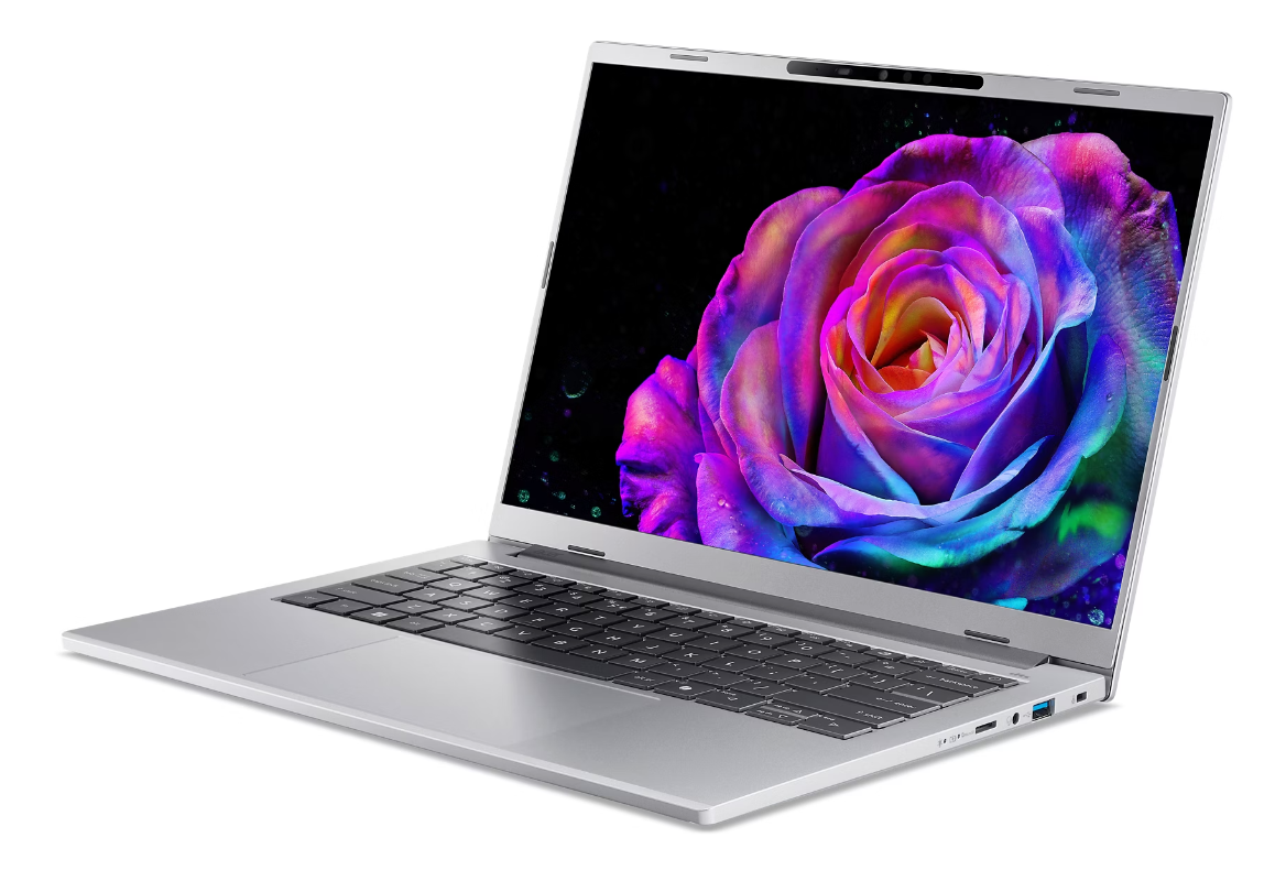 Otwarty laptop wyświetla kolorową różę na ekranie na czarnym tle.