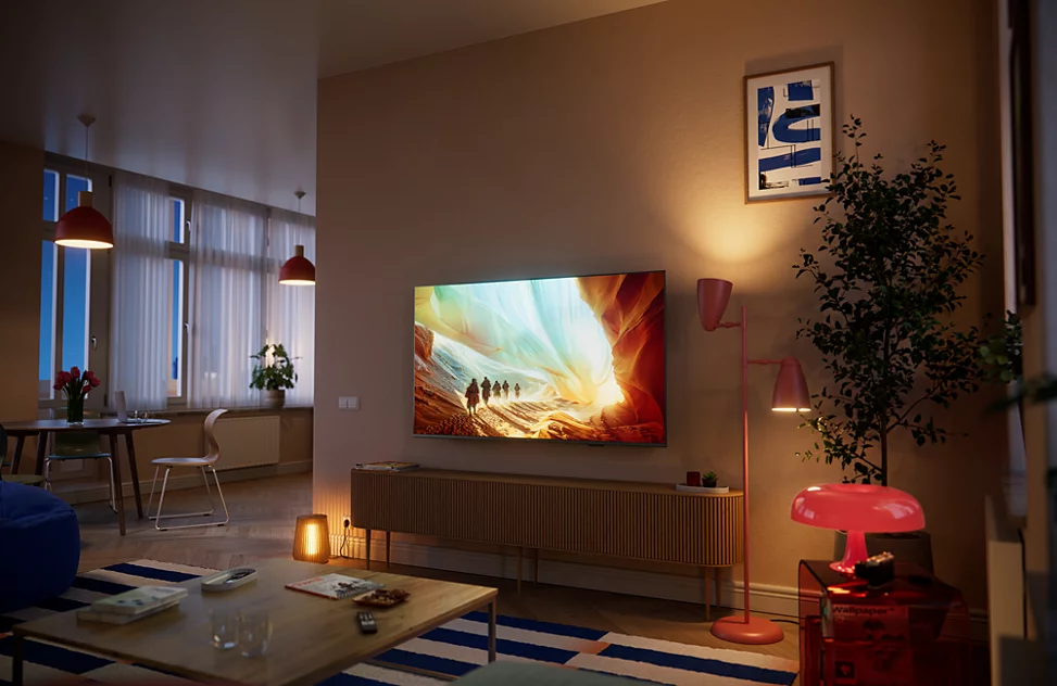 Ein Wohnzimmer mit Fernseher, der eine Schlucht zeigt, und rosa Lampen.