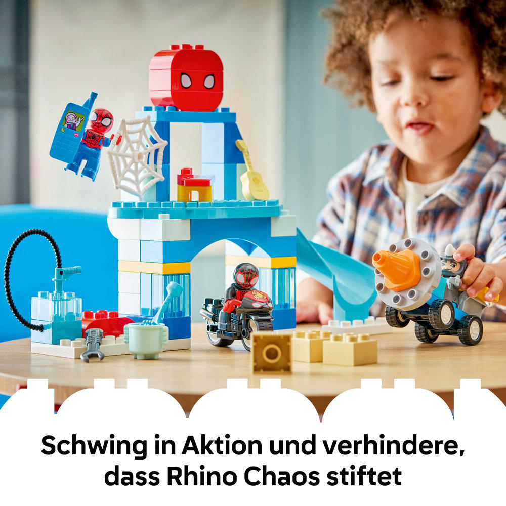 Ein Kind spielt mit einem Spiderman Lego Set mit blauer Struktur, Spiderman Figuren und Fahrzeugen.