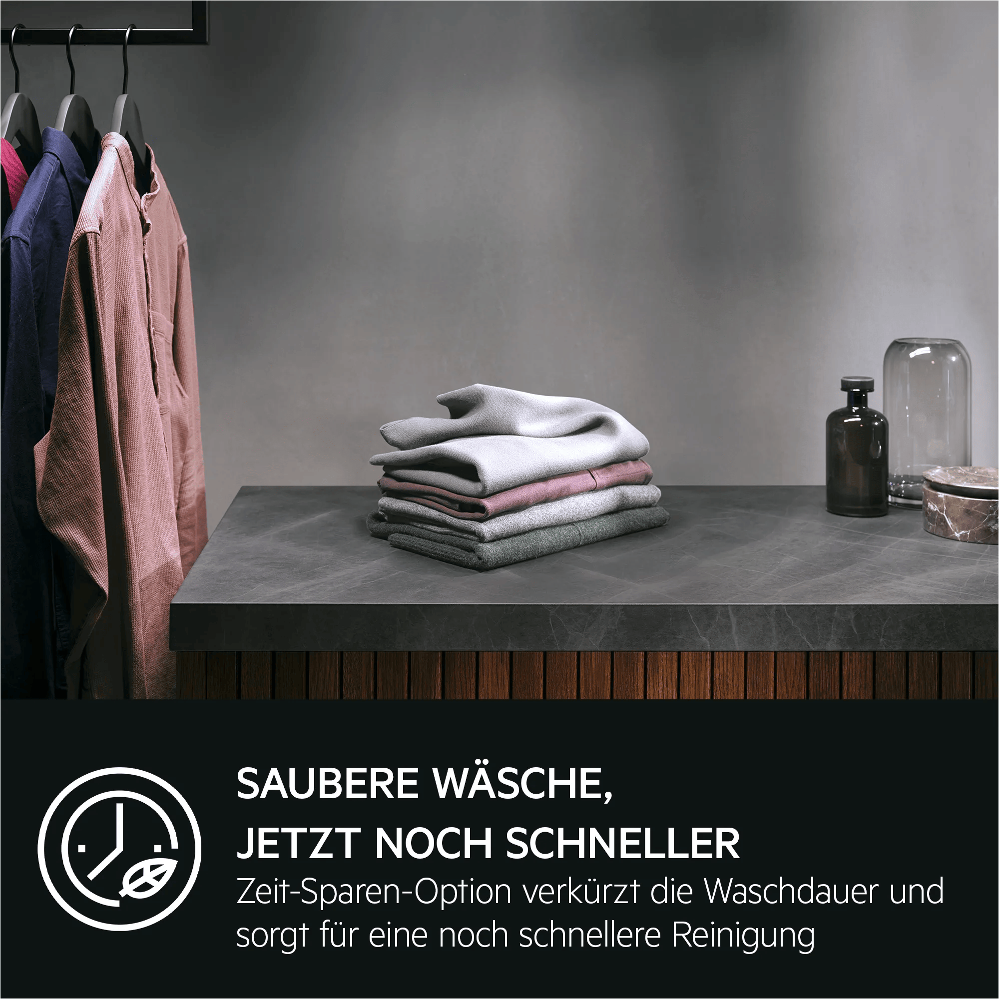 Hemden hängen an Bügeln, daneben liegen gefaltete Textilien auf einer Arbeitsplatte.