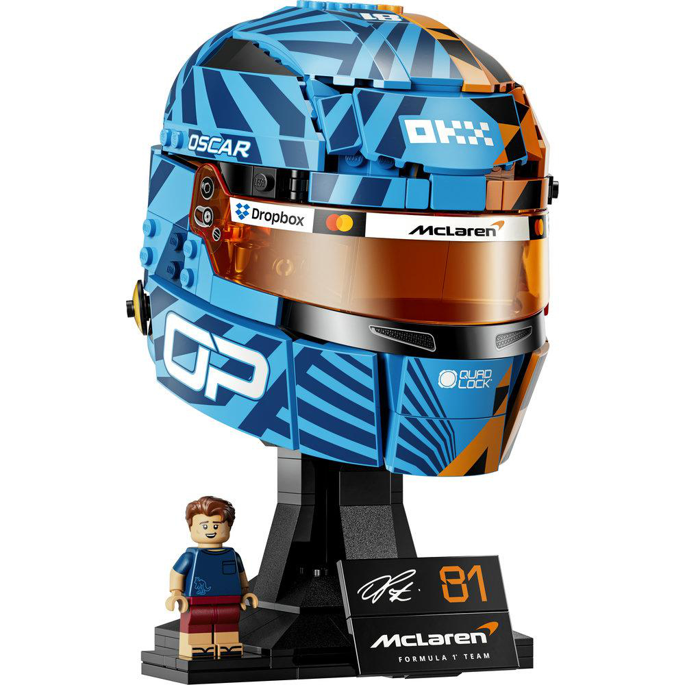 Ein LEGO-Formel-1-Helm in Blau und Orange mit einem Minifiguren-Fahrer daneben.