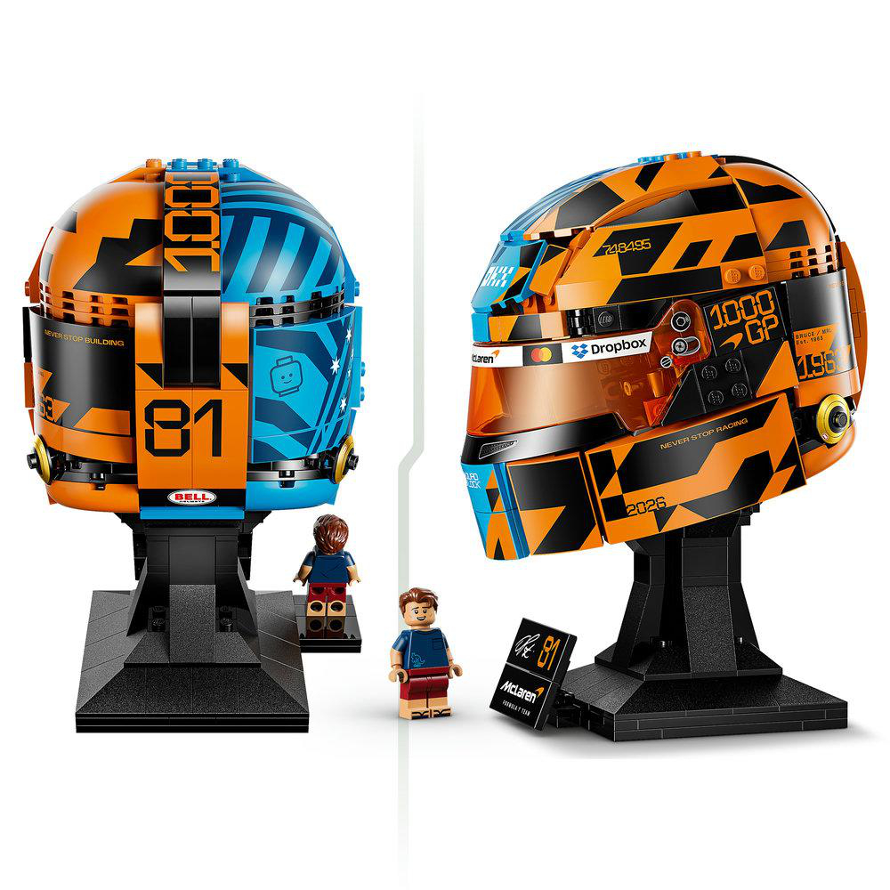 Zwei Lego-Helme, einer orange/blau, einer orange/schwarz, mit Figuren.